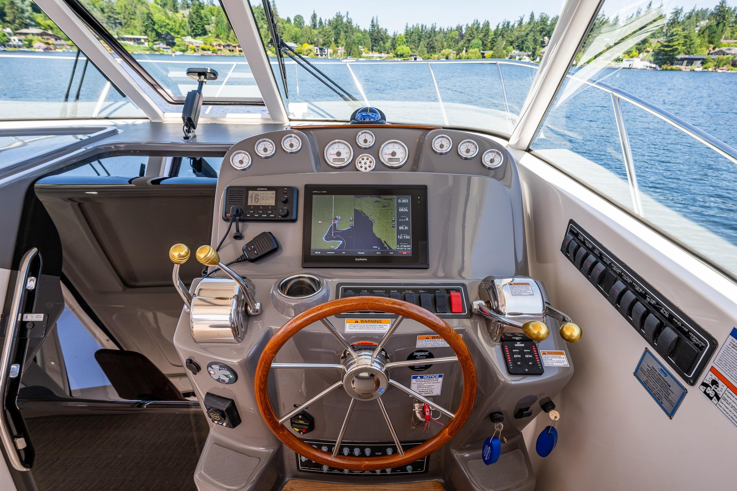 Helm of 2018 Tiara Yachts 3100 Coronet with navigation controls and scenic lake view.