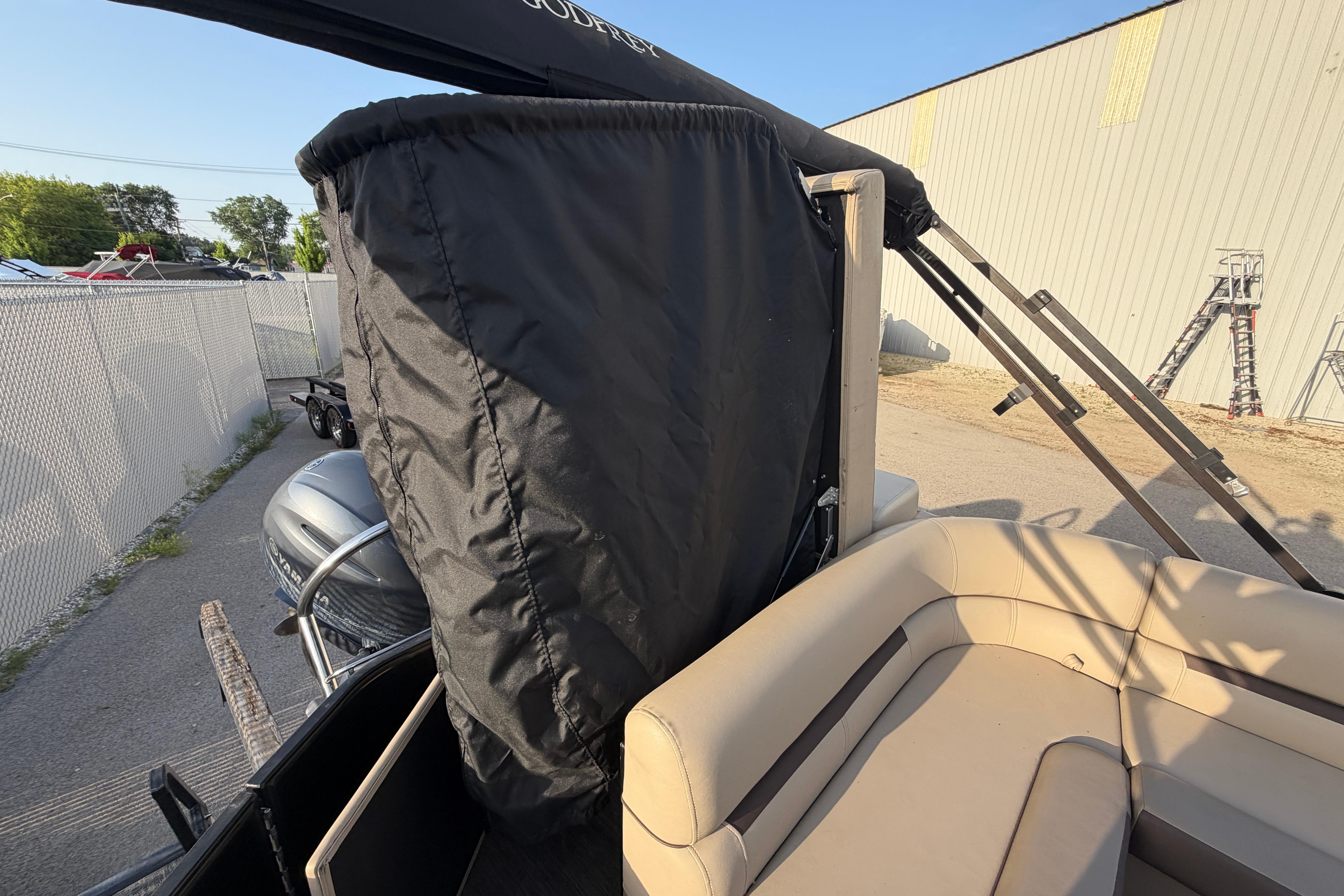 2023 Godfrey Sweetwater 2286 C pontoon boat with covered engine and beige seating.
