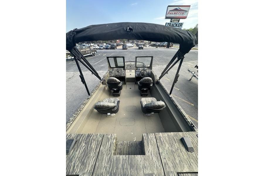 2025 SeaArk Predator 300 AK boat interior with seating and canopy, parked outdoors.