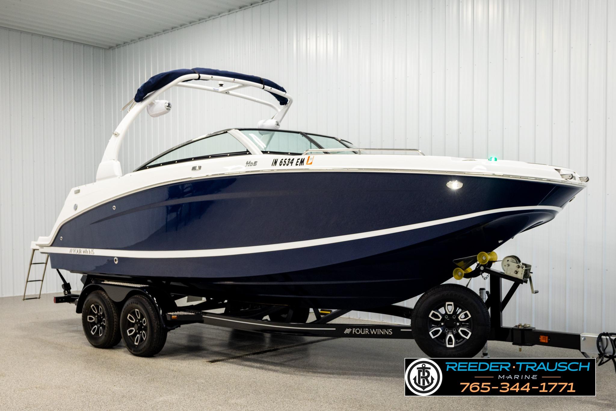 2024 FOURWINNS HD5 Surf boat on trailer in indoor showroom.