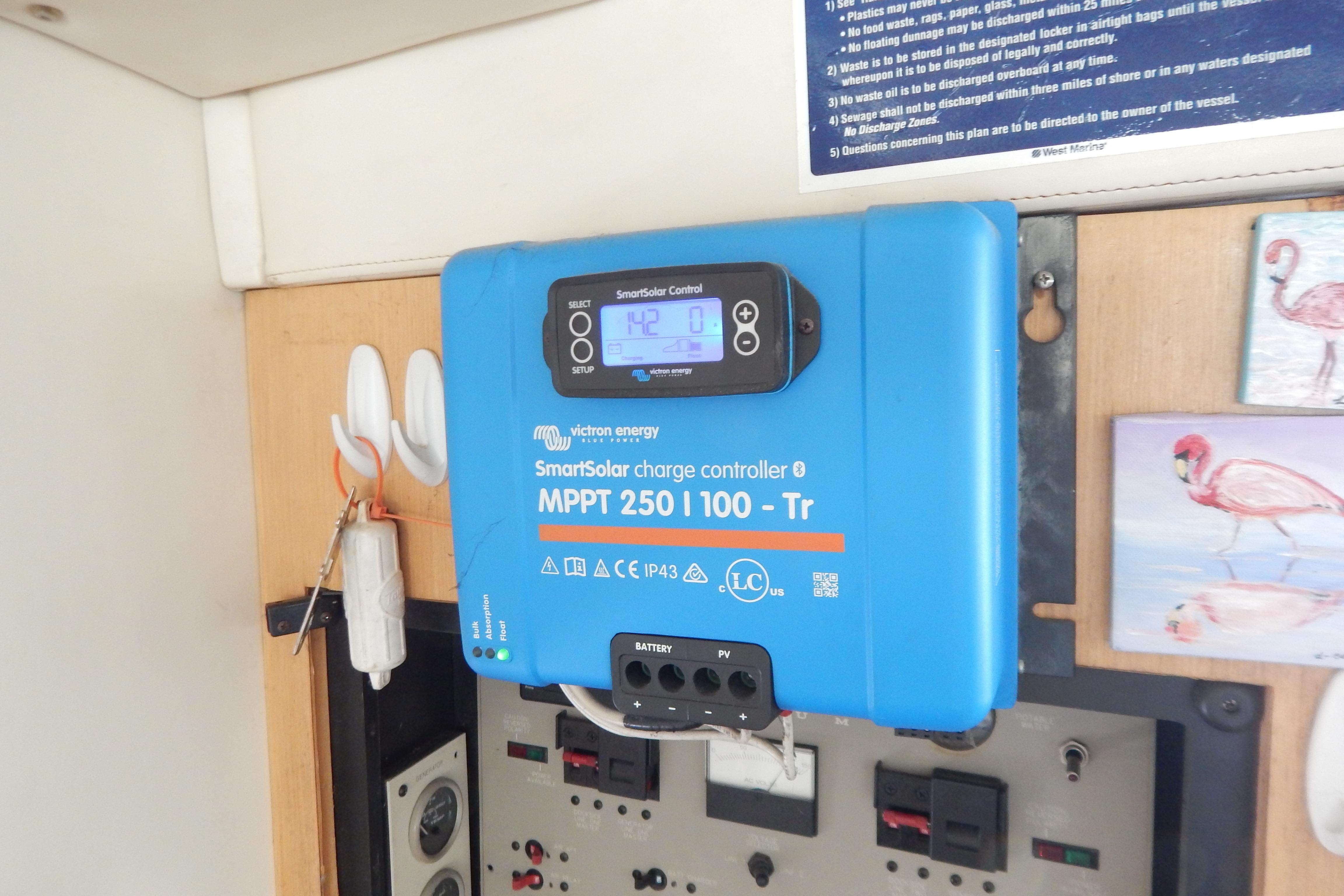 Blue Victron Energy SmartSolar charge controller mounted on a wall, next to electrical panel.