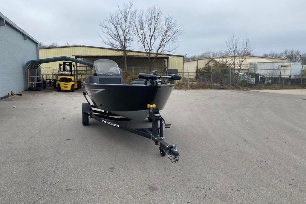 2026 Tracker Pro Guide V-16 SC boat on trailer in industrial area.