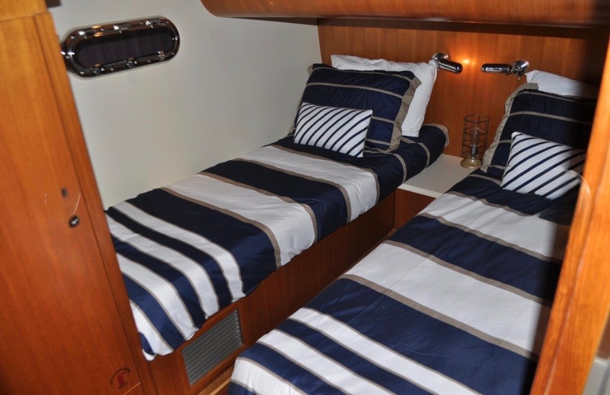 Two single beds with striped bedding in a cozy wooden cabin.
