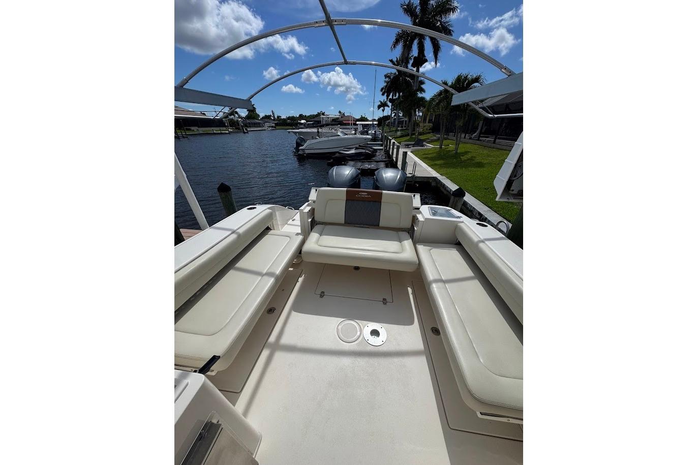 2020 Cobia 280 Dual Console boat interior with seating, docked by a waterfront.