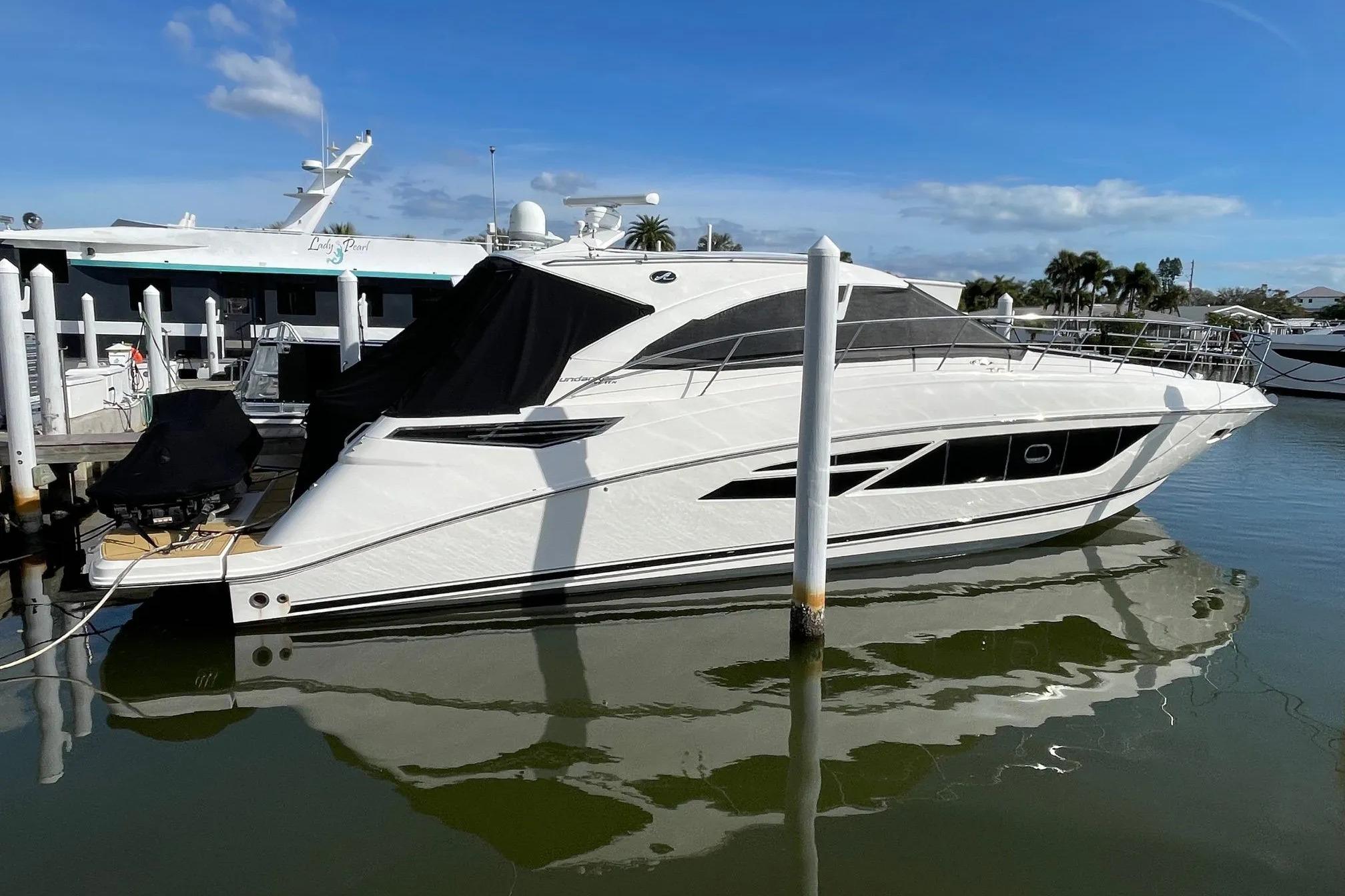 2016 Sea Ray Sundancer 510 yacht docked in a marina, reflecting on calm water.