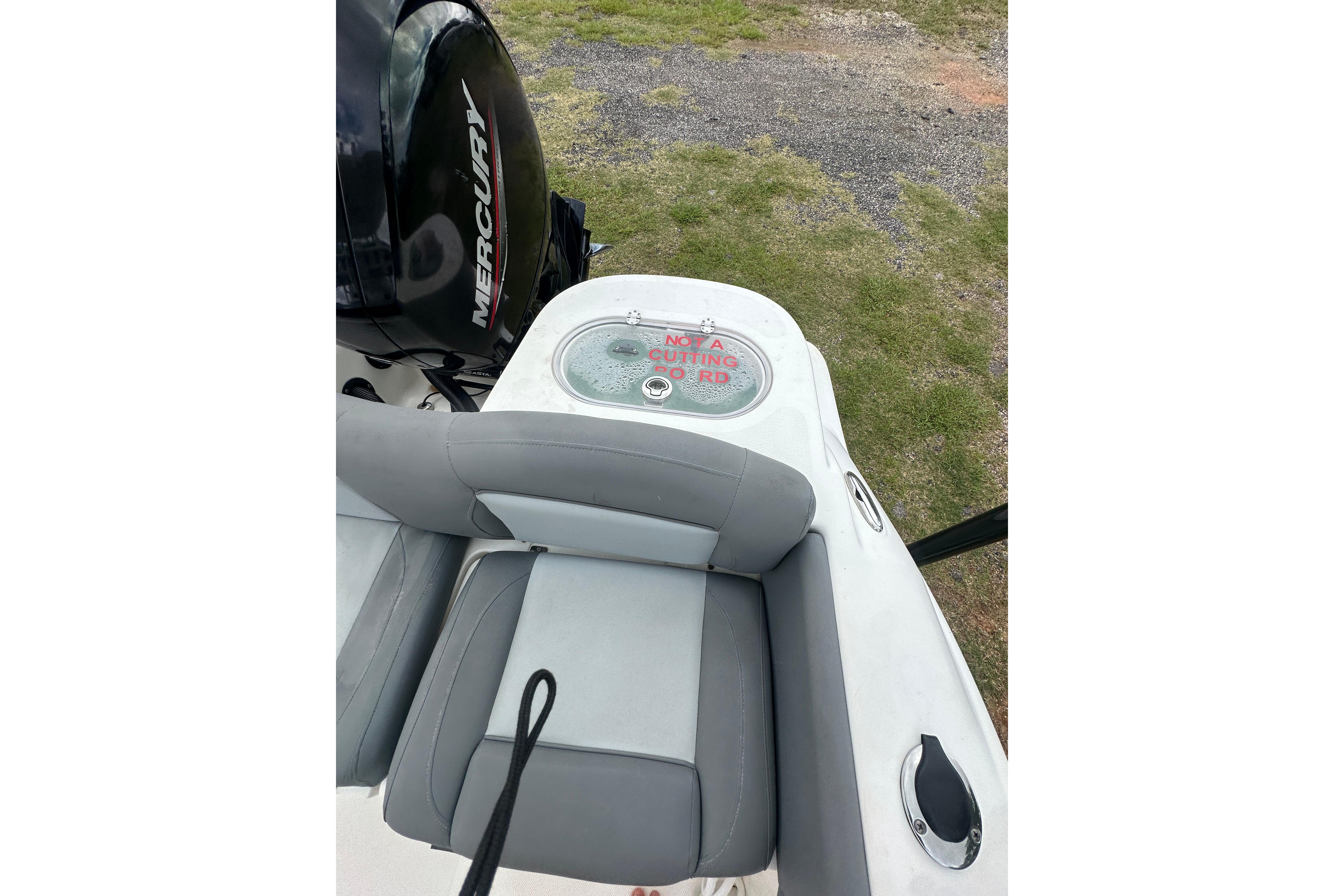 2023 NauticStar 2102 Legacy boat interior with Mercury engine and seating area.
