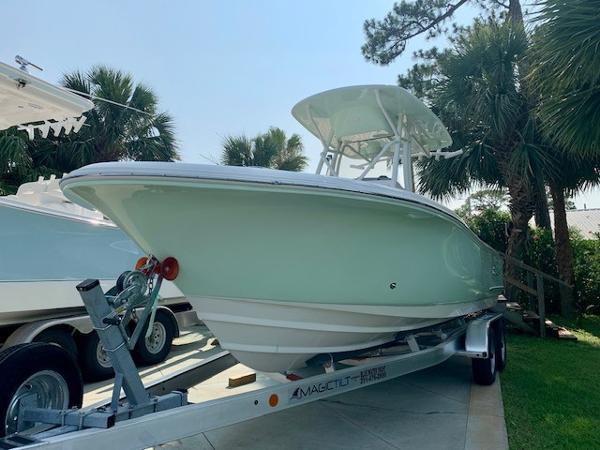 2025 Pioneer 222 Islander boat on trailer, surrounded by palm trees.