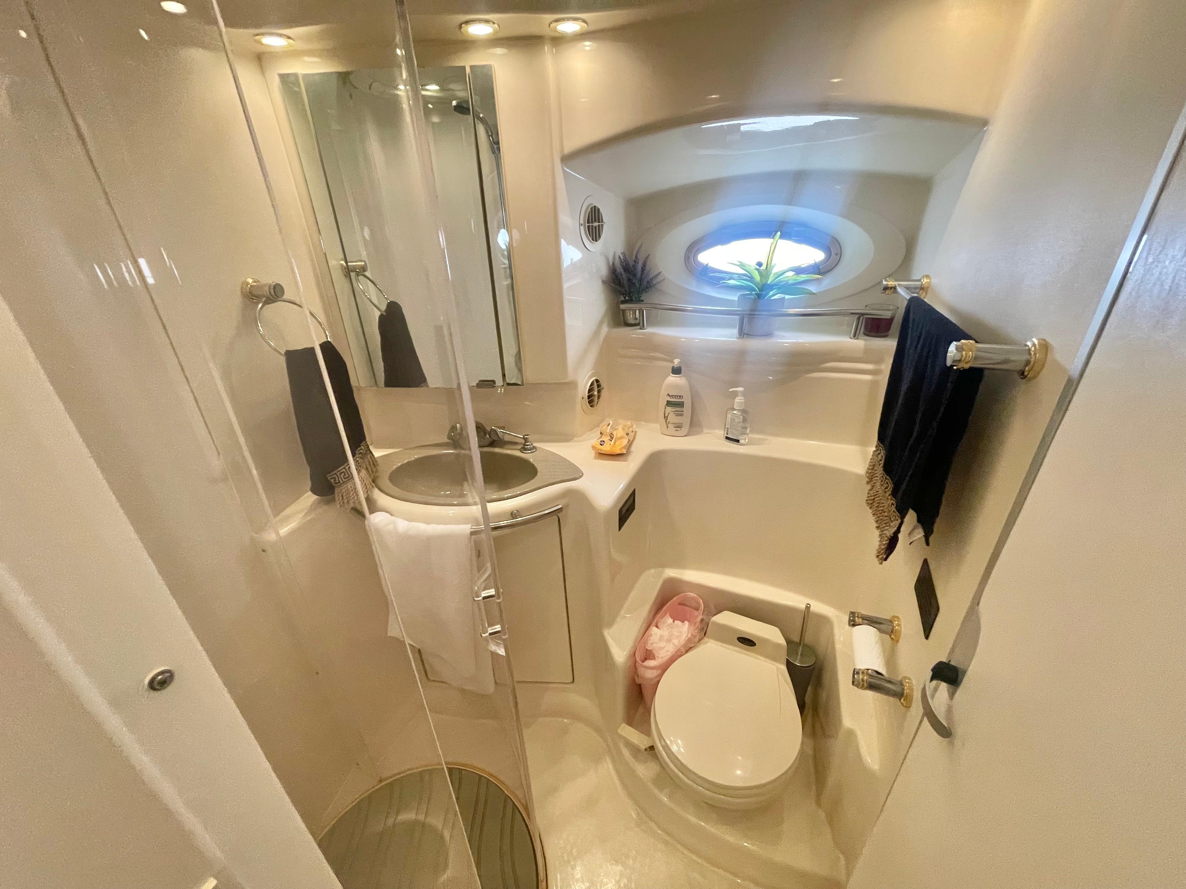 Luxurious bathroom in 1998 Maxum 4100 SCA yacht with modern fixtures and elegant design.