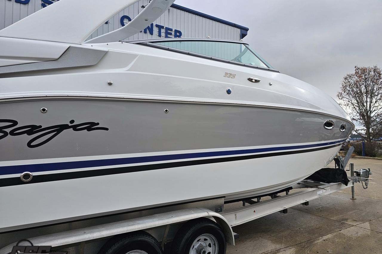 2008 Baja 335 Performance boat on trailer, white and gray with blue accents.