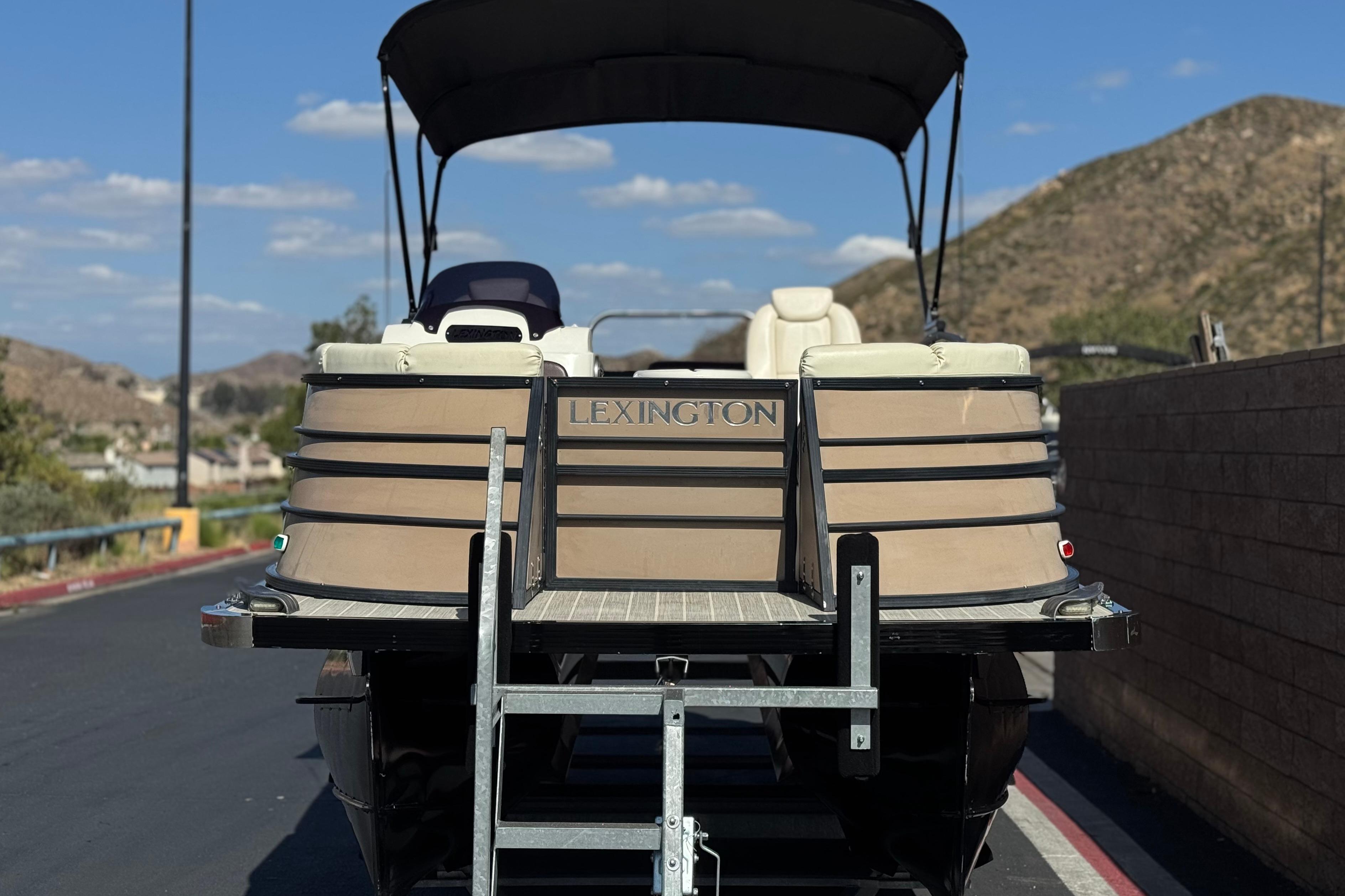 2023 Lexington 623 ST Xtreme pontoon boat on trailer, scenic mountain backdrop.