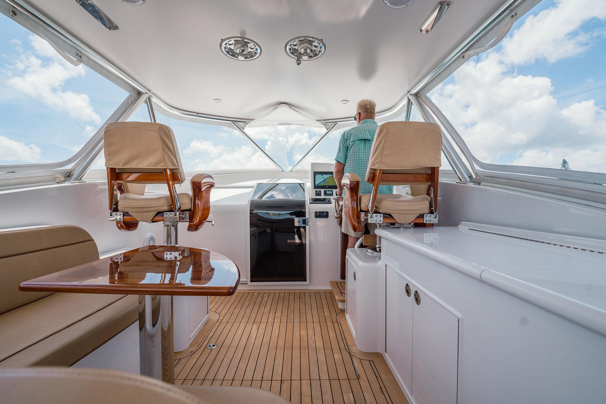 2012 Winter Custom Yachts 38 Express interior with helm, seating, and wooden flooring.