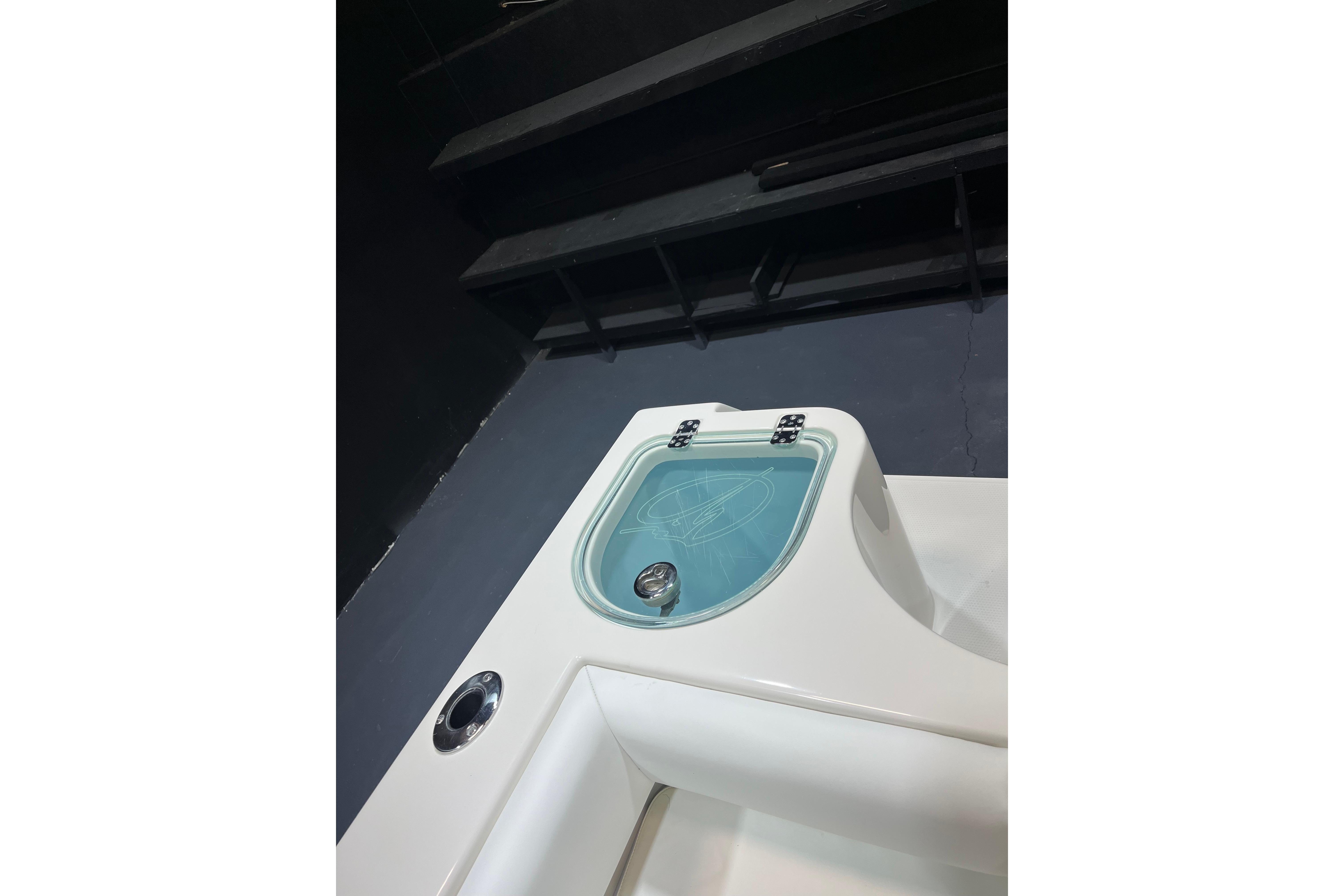 2022 Sailfish 242 CC boat detail with blue livewell and sleek white design.