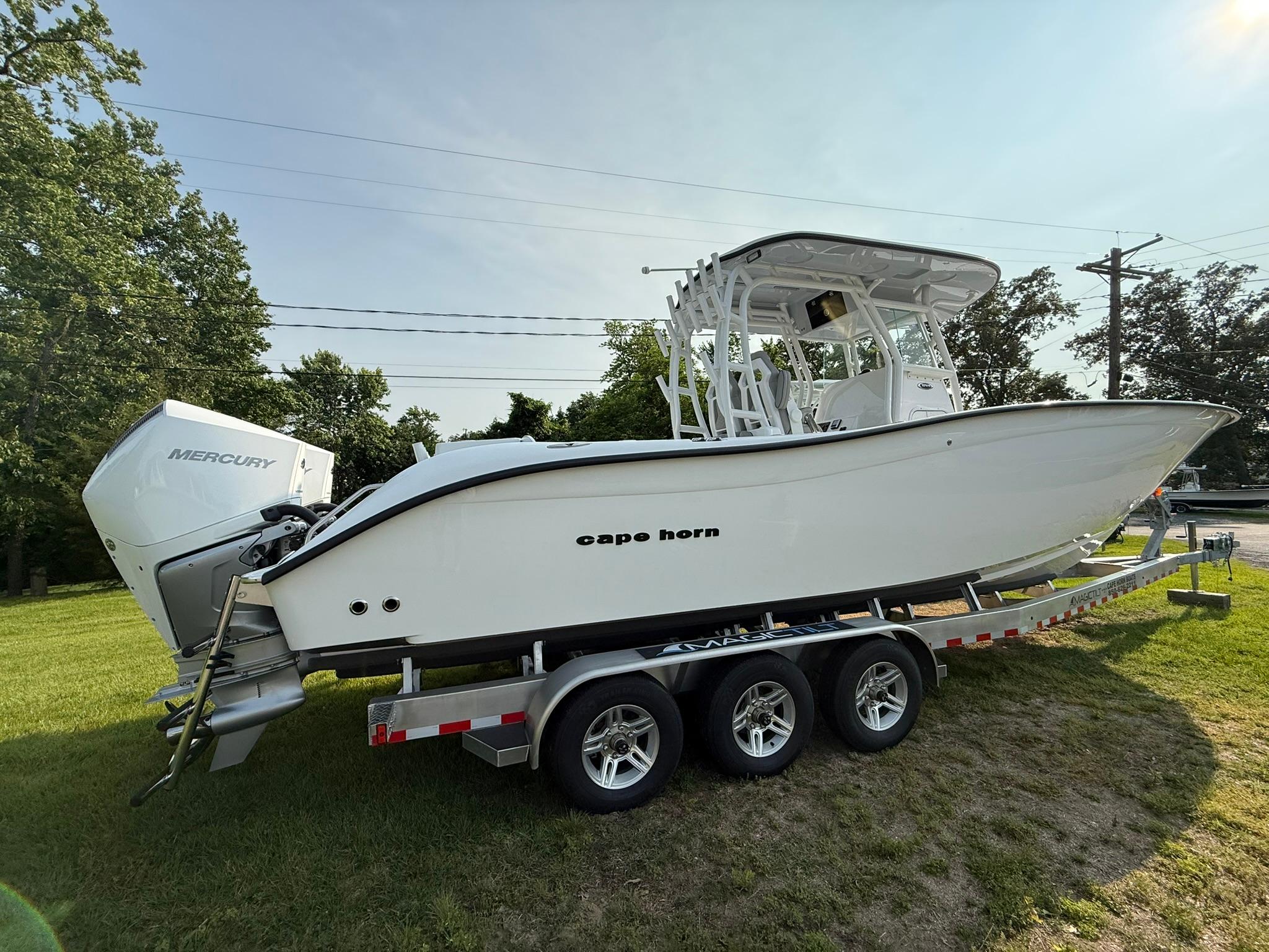 2025 Cape Horn 32 XS boat on trailer, parked on grass, side view.