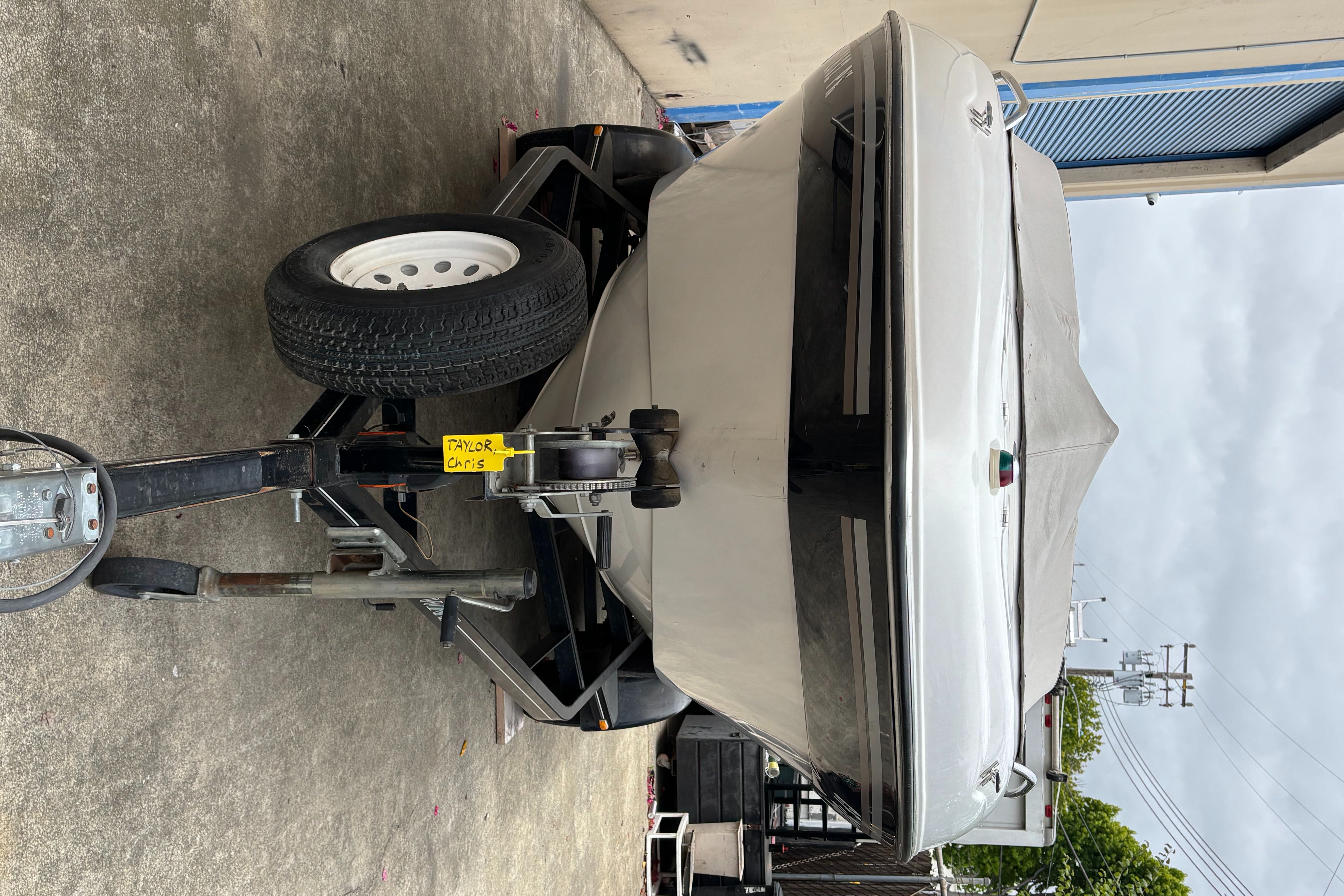 A 2000 Four Winns 220 Horizon boat on a trailer, covered and ready for transport.