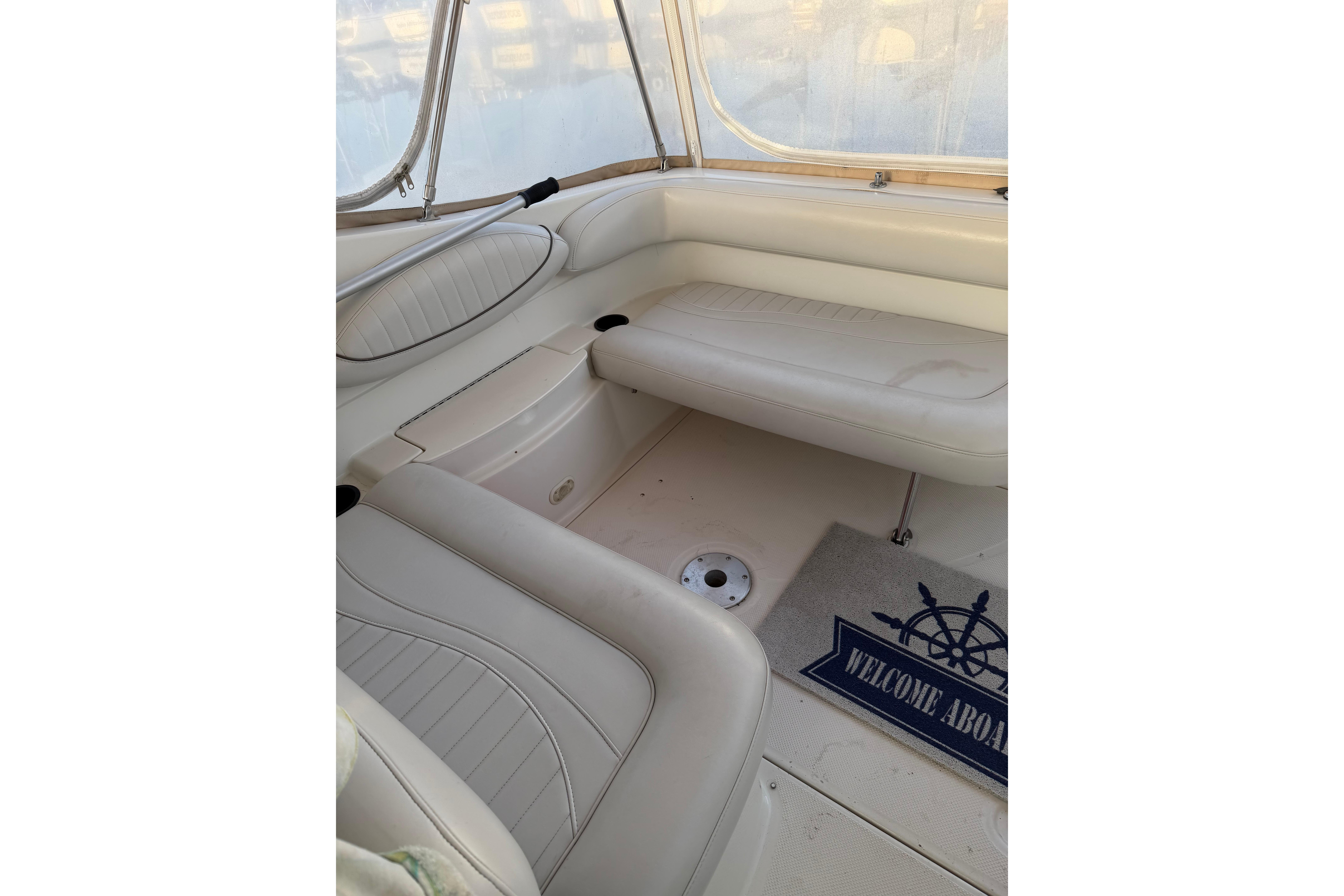 Interior of 2001 Maxum 2800 SCR boat with white seating and "Welcome Aboard" mat.