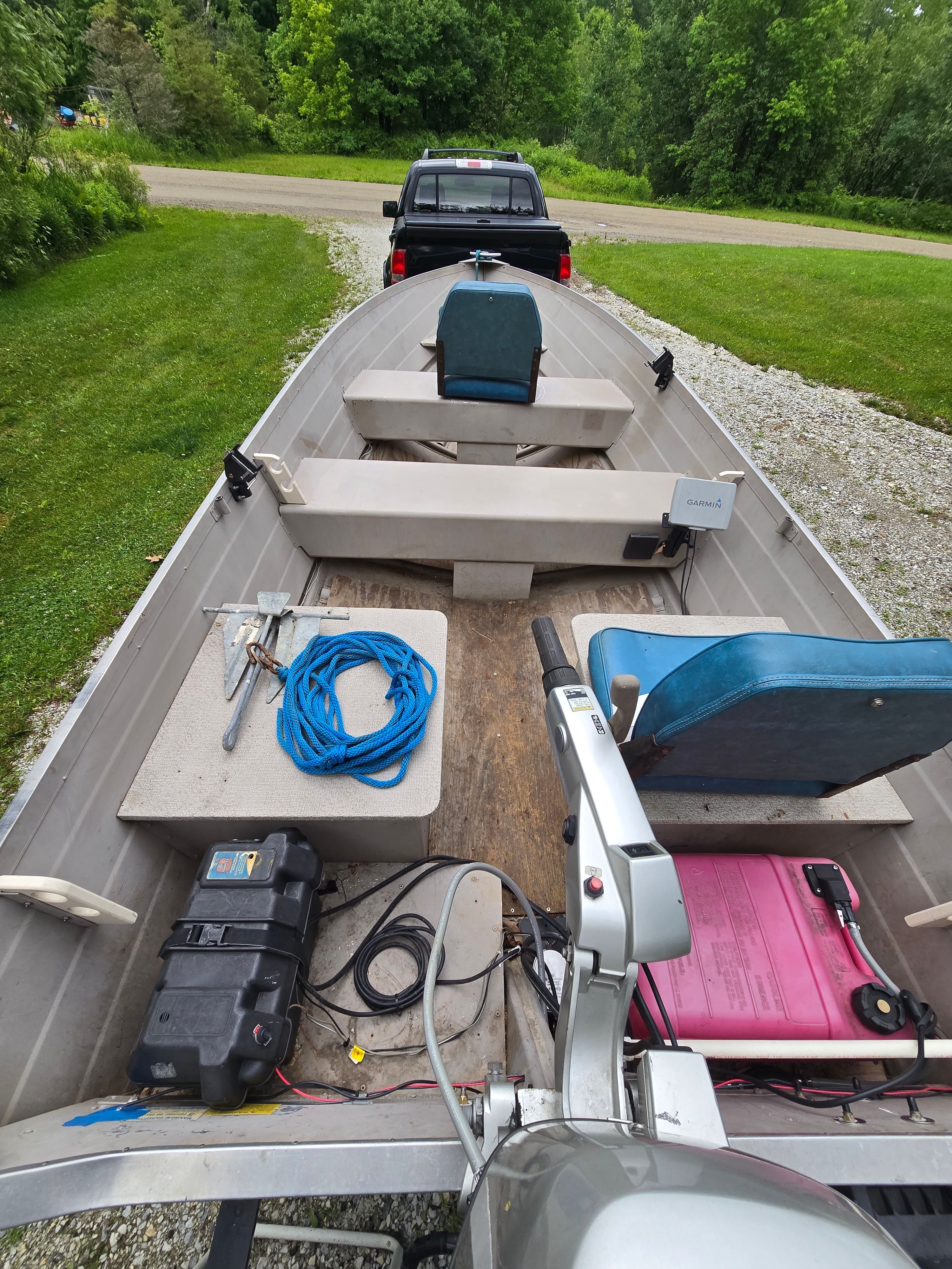 A 2002 Starcraft SF 14 L SS Utility Boat on a trailer, surrounded by trees.