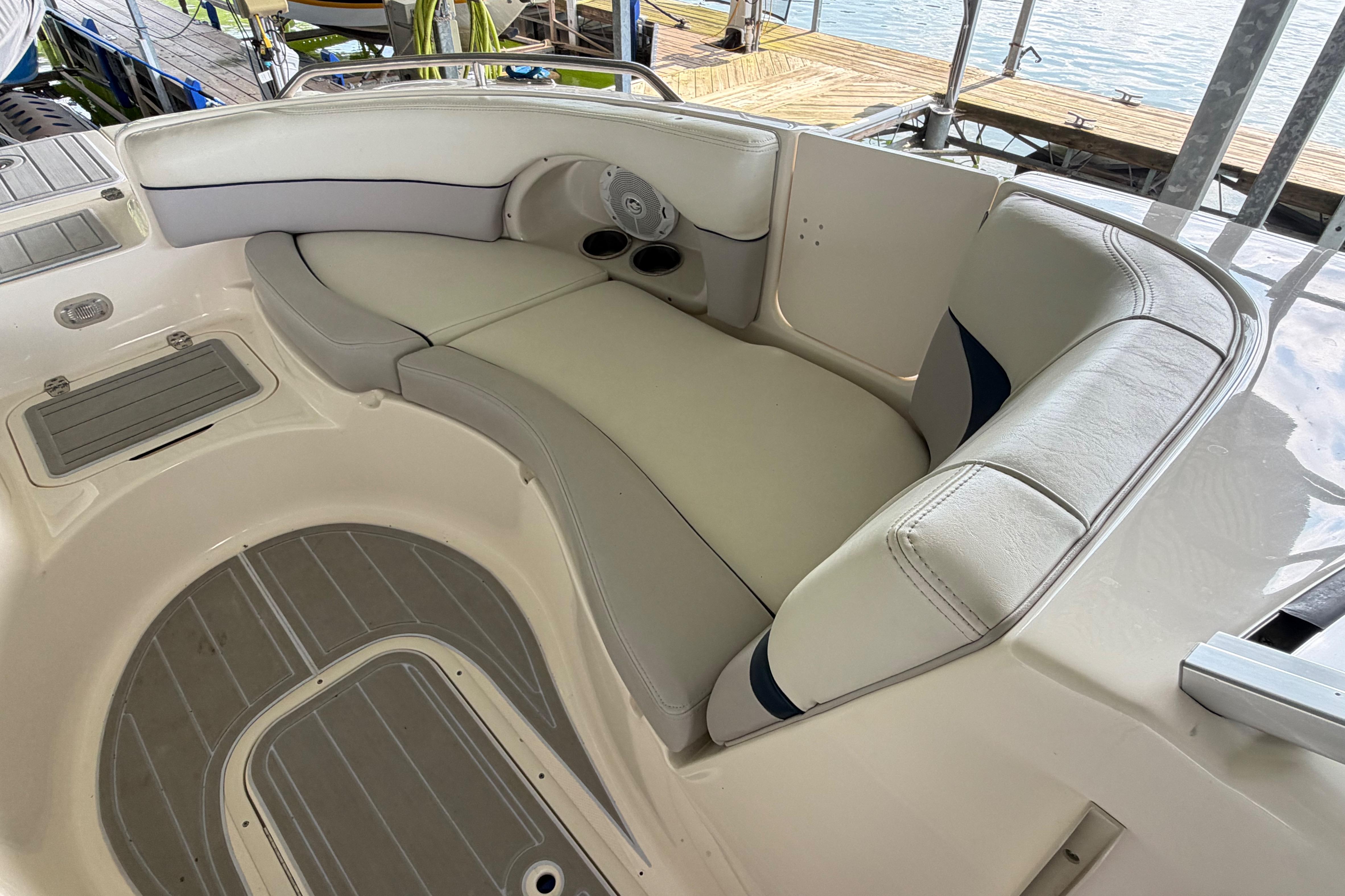 Luxurious seating area on a 2010 Bryant 255 boat, featuring comfortable white upholstery.