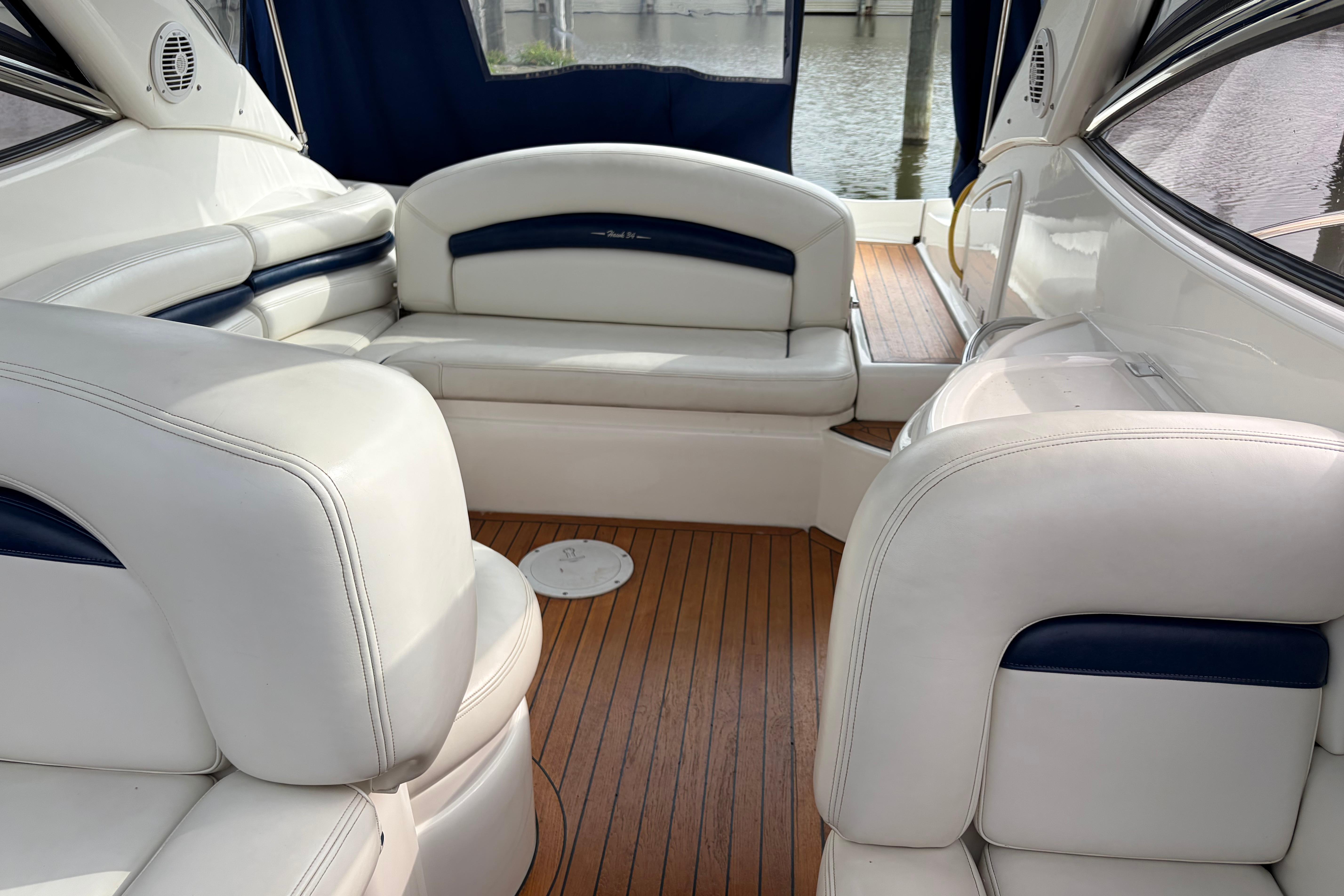 Luxurious interior of 2000 Sunseeker Superhawk 34 yacht with white leather seating and wood flooring.
