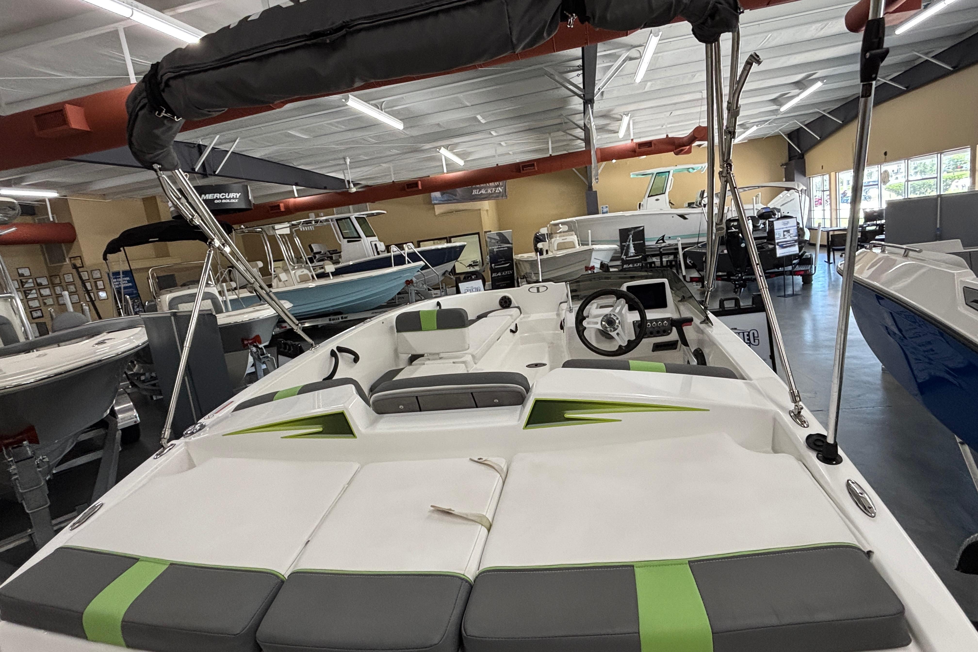 2024 Tahoe T18 boat interior with modern seating and steering, displayed in a showroom.