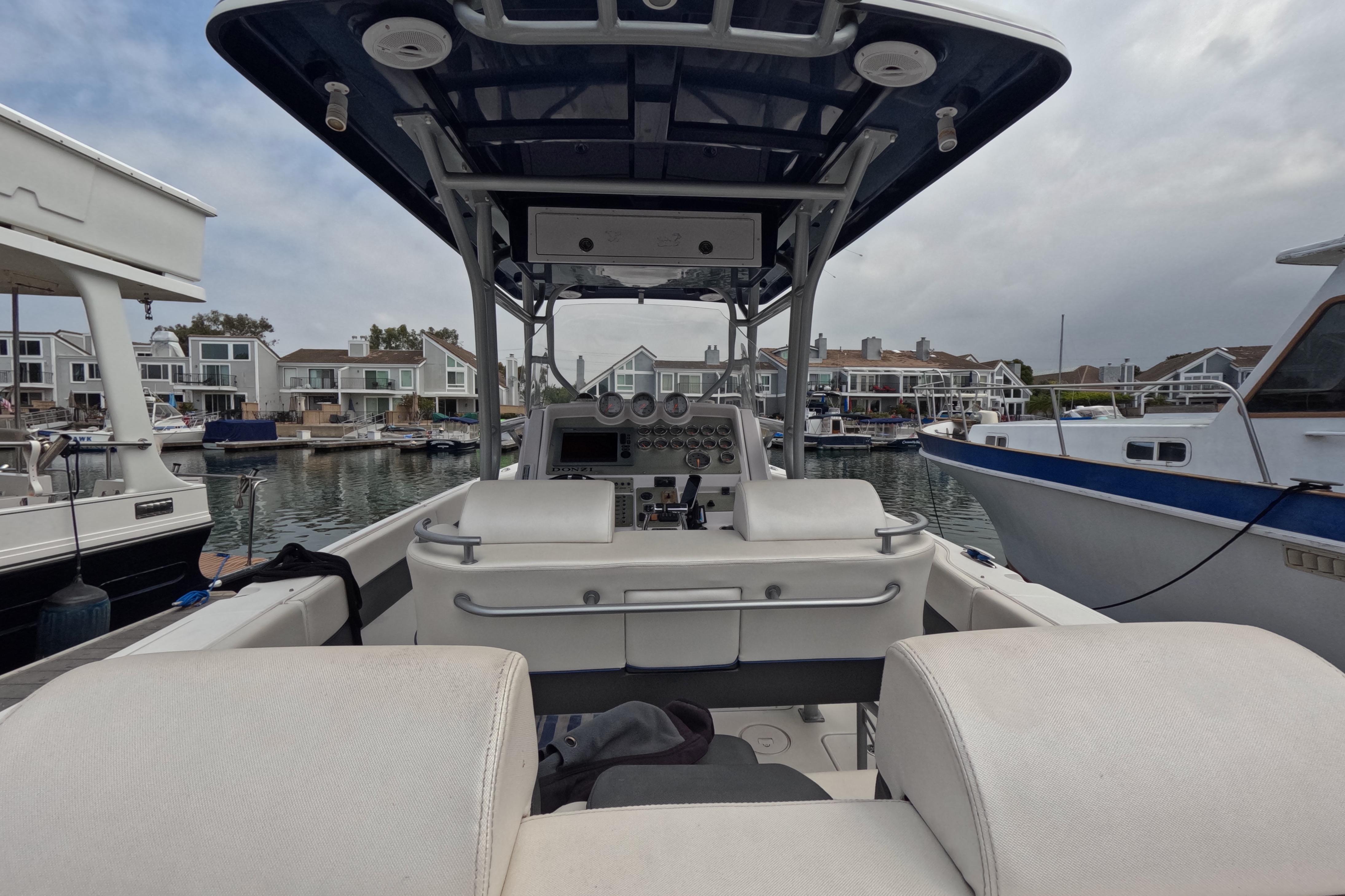 2011 Donzi 38 ZFX Open boat interior at marina, showcasing helm and seating.