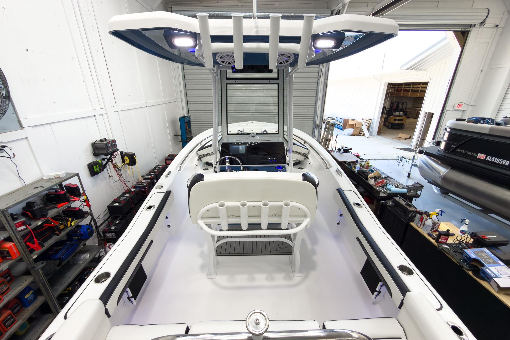 The image shows the interior of a modern boat with white seating and a blue canopy.
