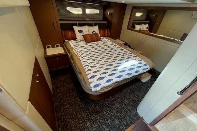 Luxurious bedroom interior of 2016 Sea Ray Sundancer 510 yacht with cozy bedding.