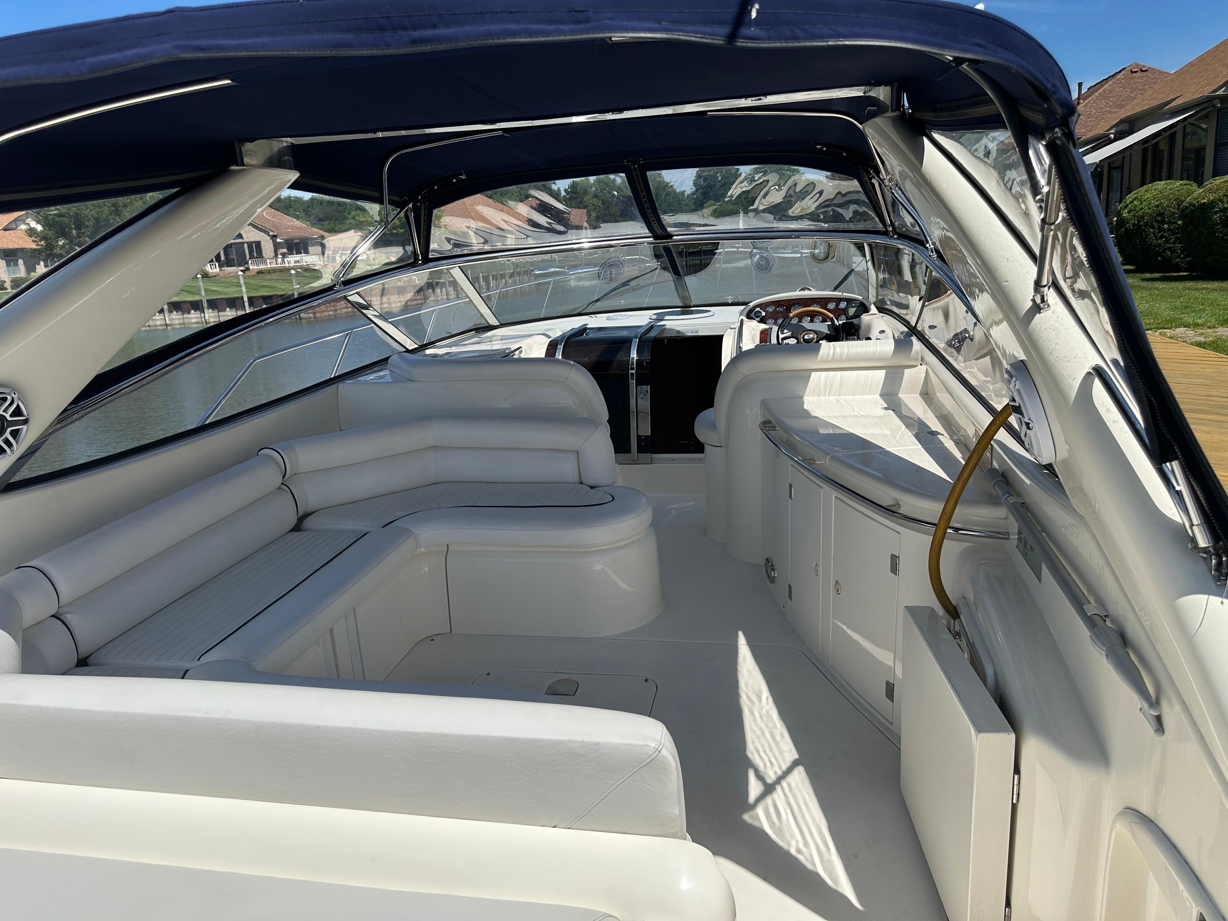 1997 Sunseeker Camargue 47 yacht interior with white seating and blue canopy.