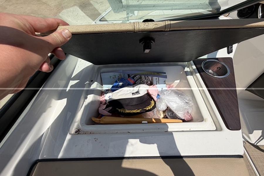 Storage compartment of a 2018 Sea Ray SPX 190 boat, containing various items.