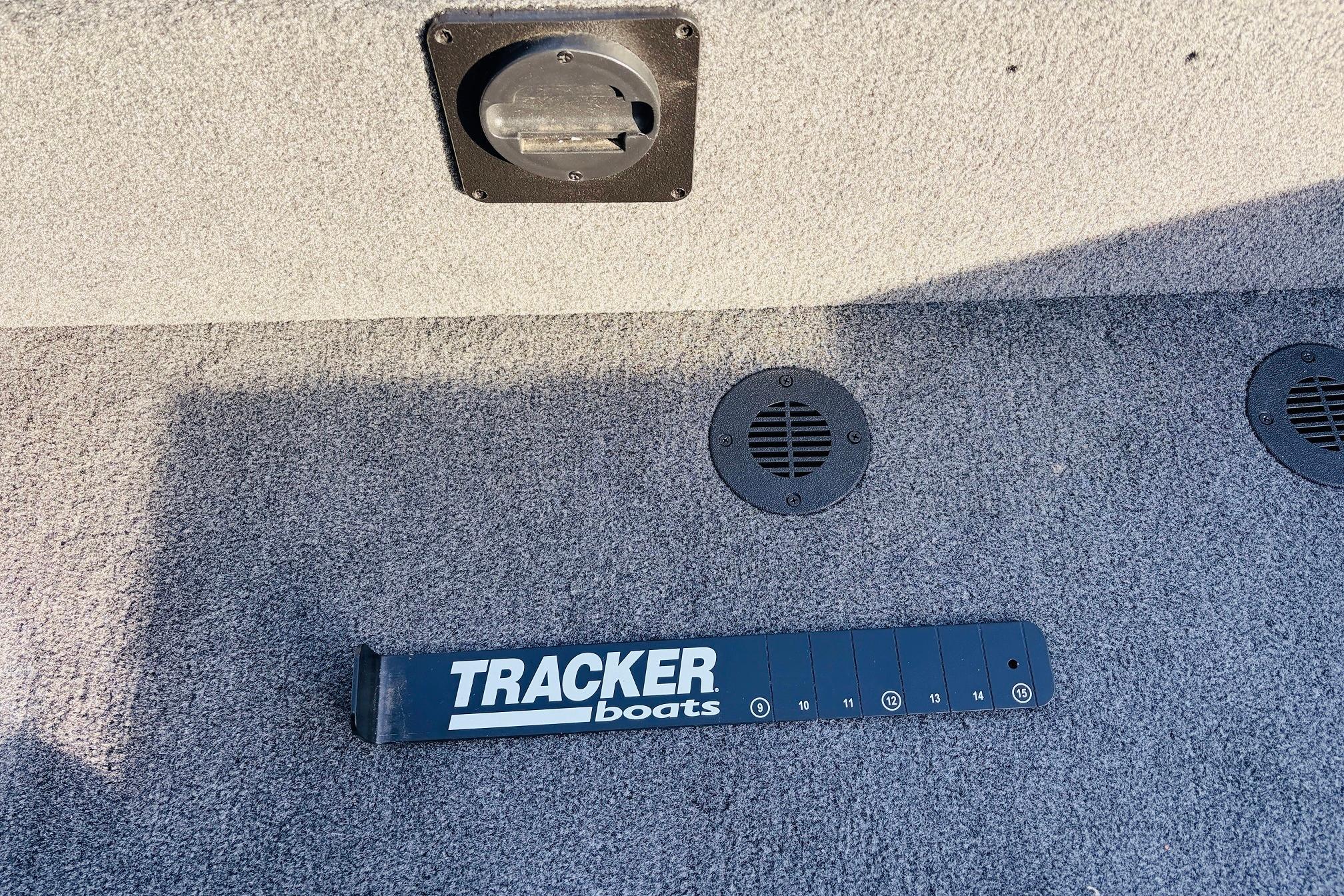 Carpeted deck of 2025 Tracker Savage 215 boat with Tracker-branded measuring tool.
