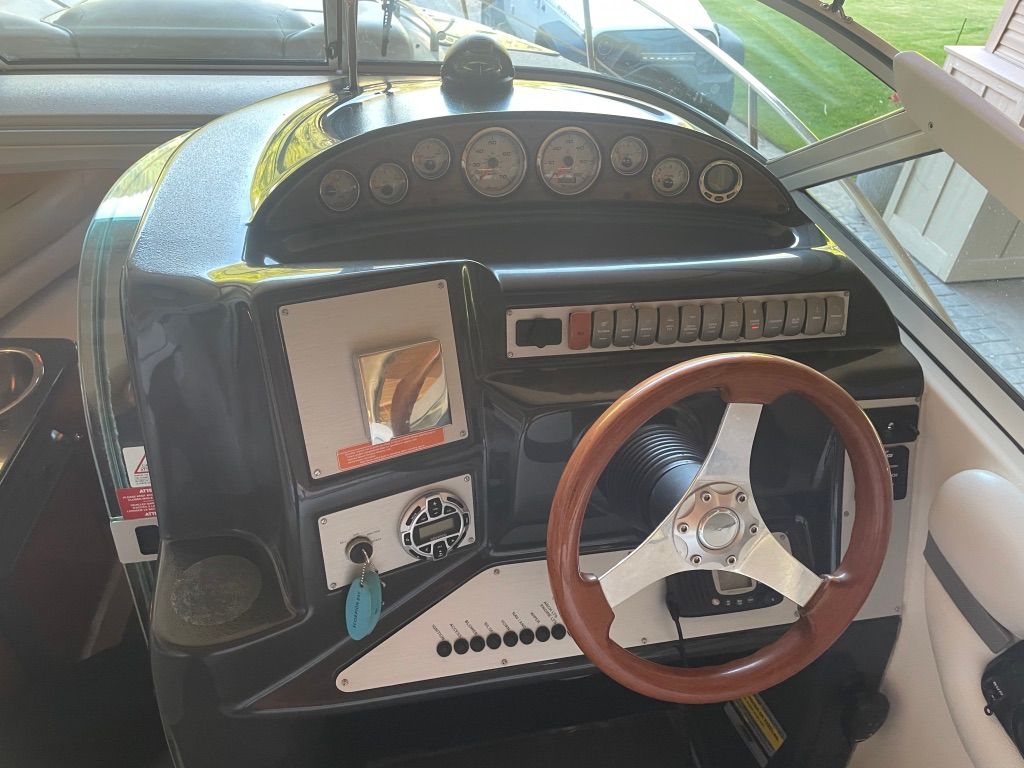 The image shows the helm of a 2007 Doral Monticello boat with a wooden steering wheel.