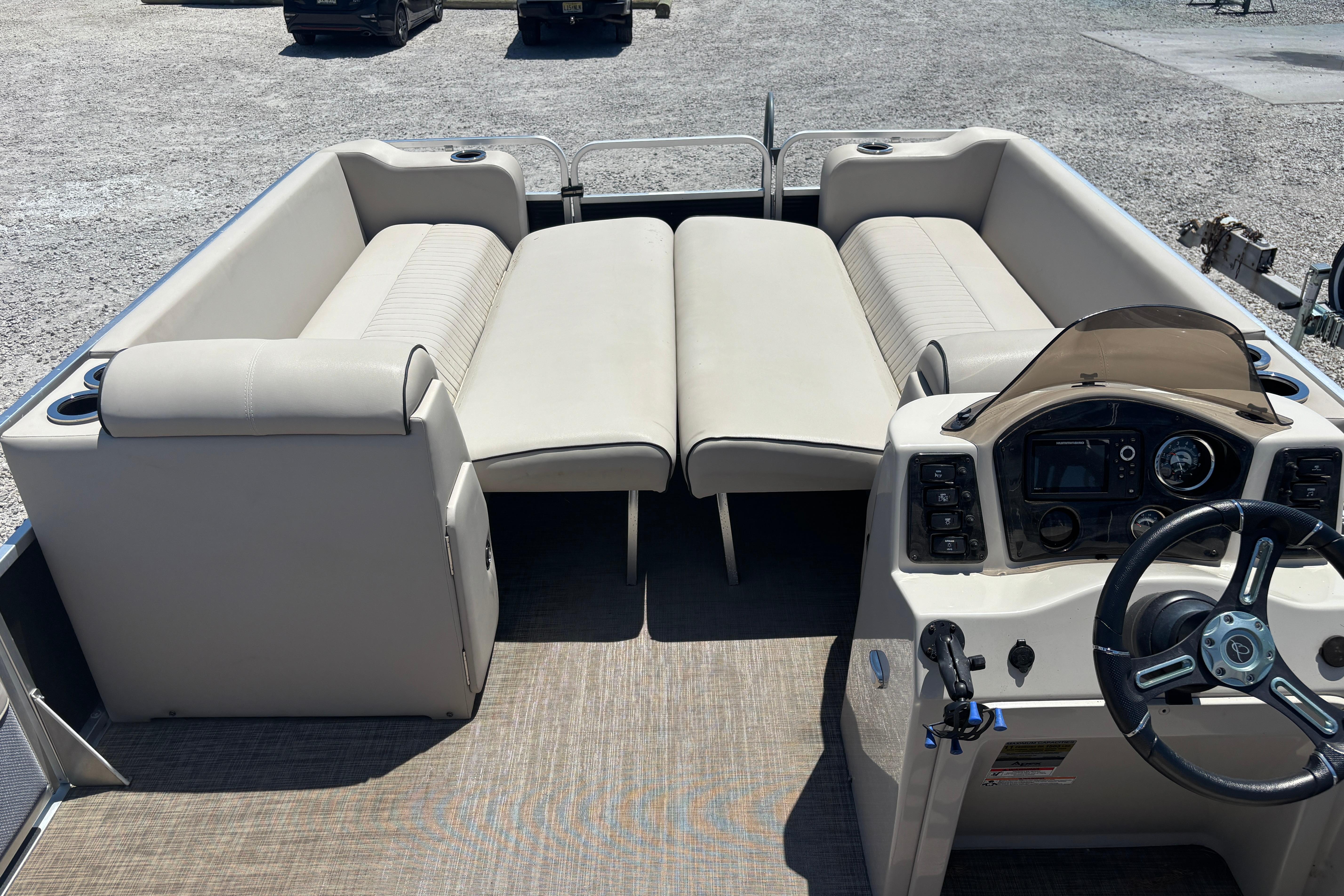 2017 Qwest LS 822 Bar pontoon boat interior with beige seating and steering console.