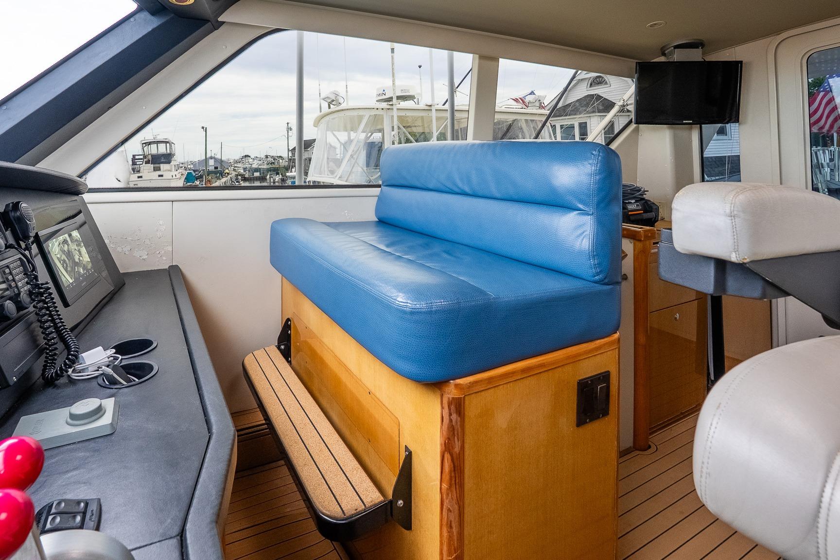Interior of 2002 Viking 61 Enclosed Bridge yacht with blue seating and navigation equipment.