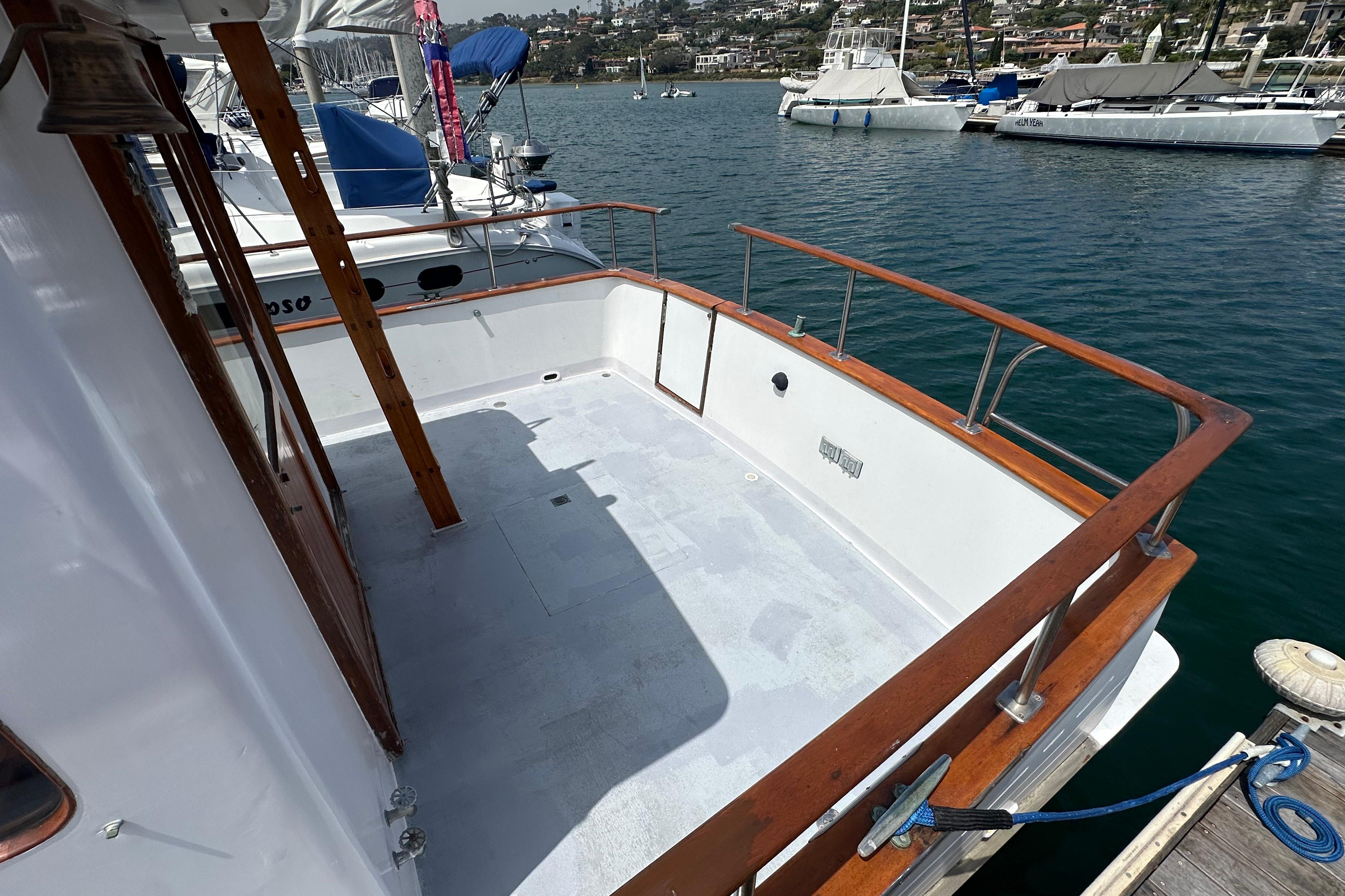 1973 CHB 33 boat deck with wooden railings docked at a marina.