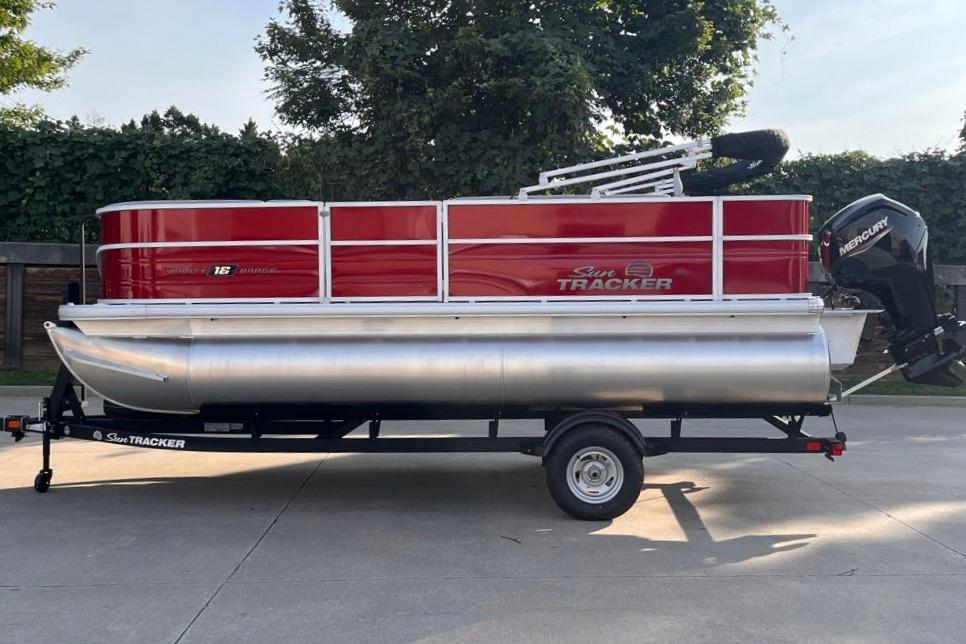 2026 Sun Tracker Party Barge 18 DLX pontoon boat on trailer, red and silver design.