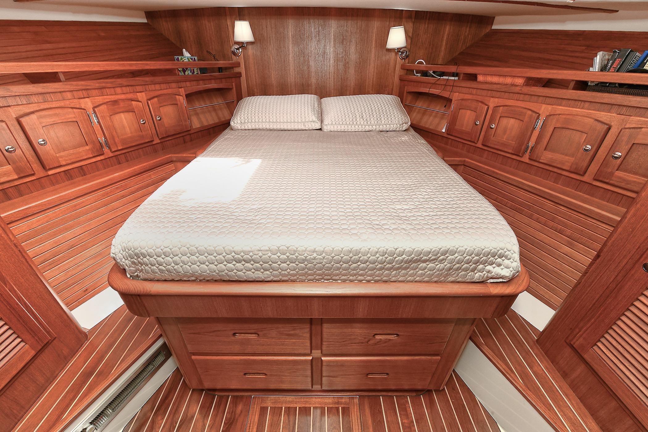 Luxurious wooden cabin interior of 2005 San Juan Downeast Express yacht with cozy bed.