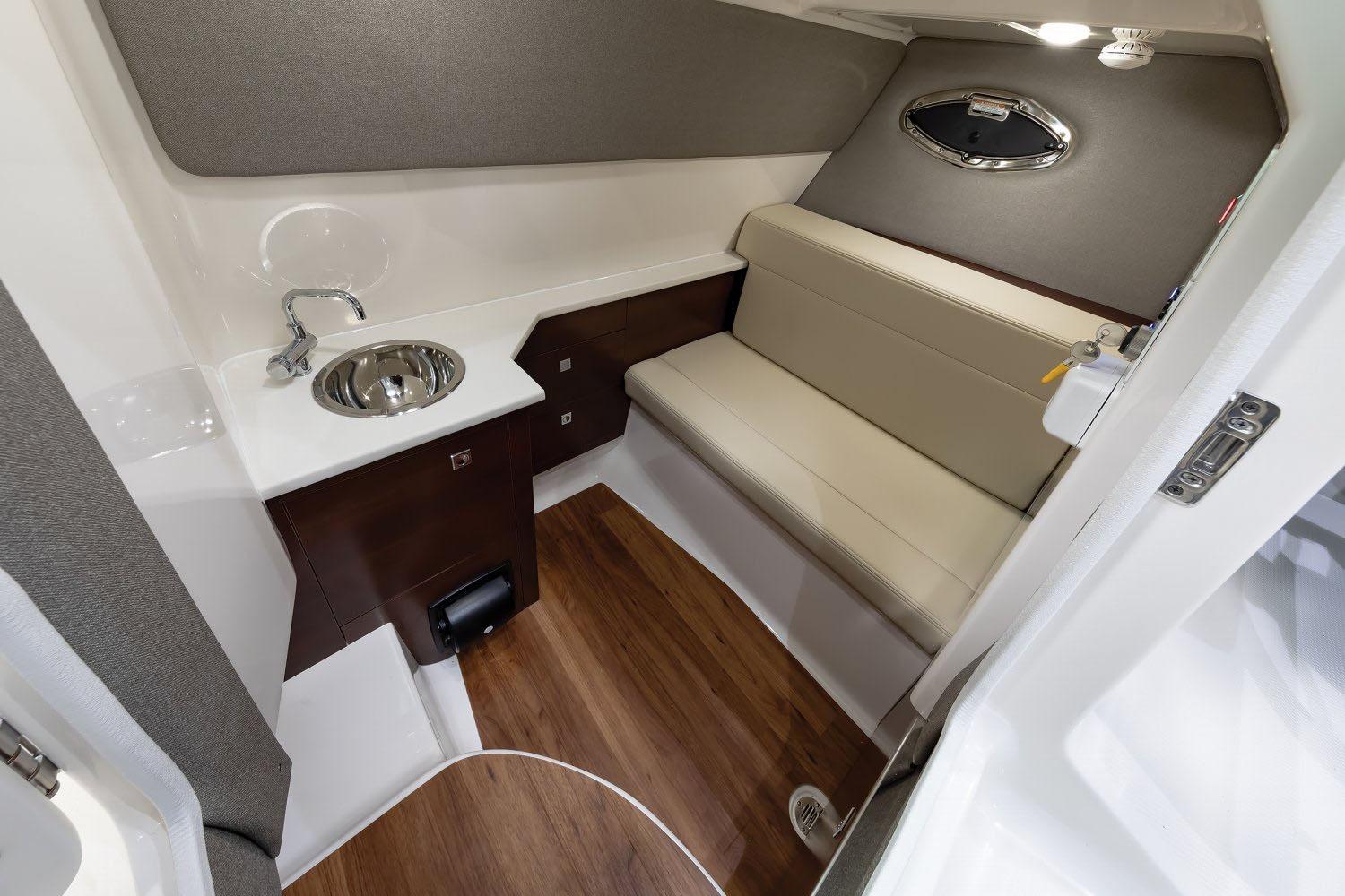 Manufacturer Provided Image: 2025 Chaparral 280 OSX cabin interior with sink, seating, and wood flooring.