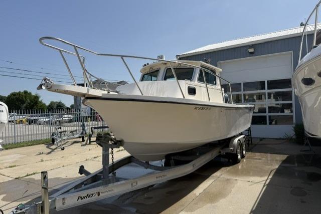 2006 Parker 2520 SL Sport Cabin boat on trailer outside a garage.