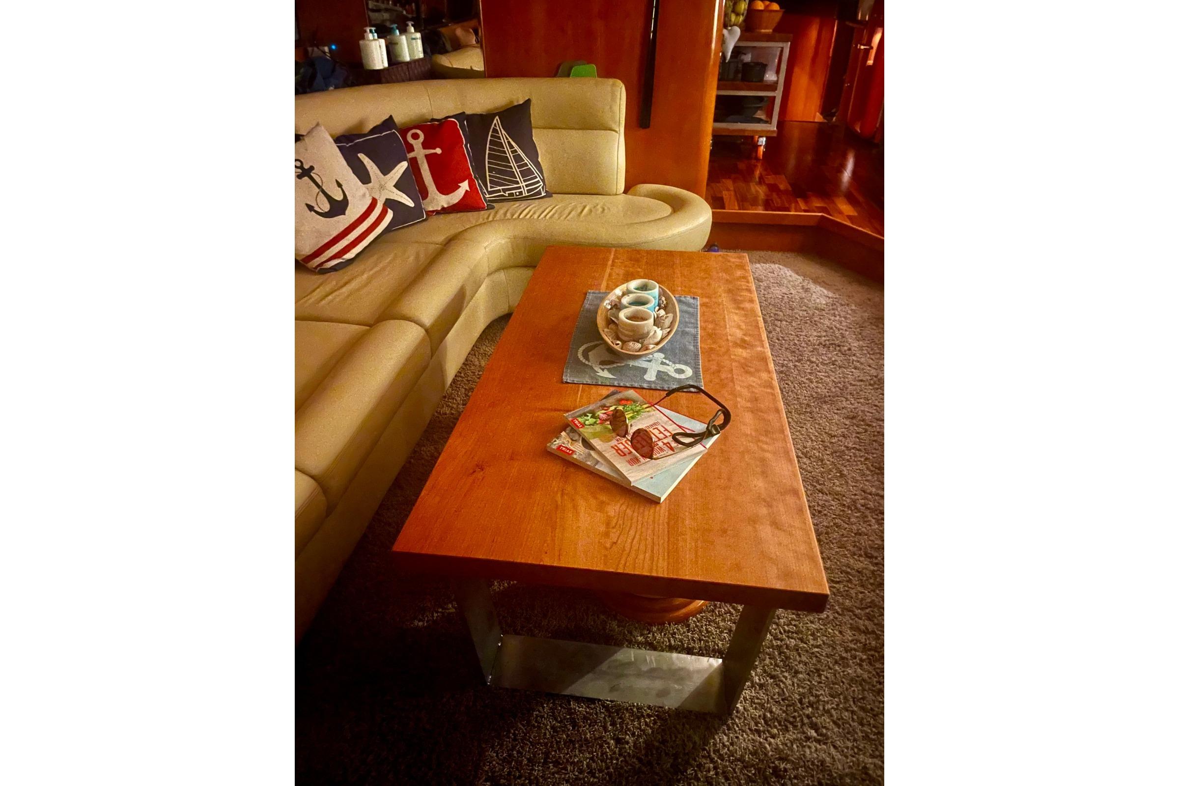 Cozy yacht interior with nautical-themed pillows, wooden table, and magazines, Elegance 64, 2007.