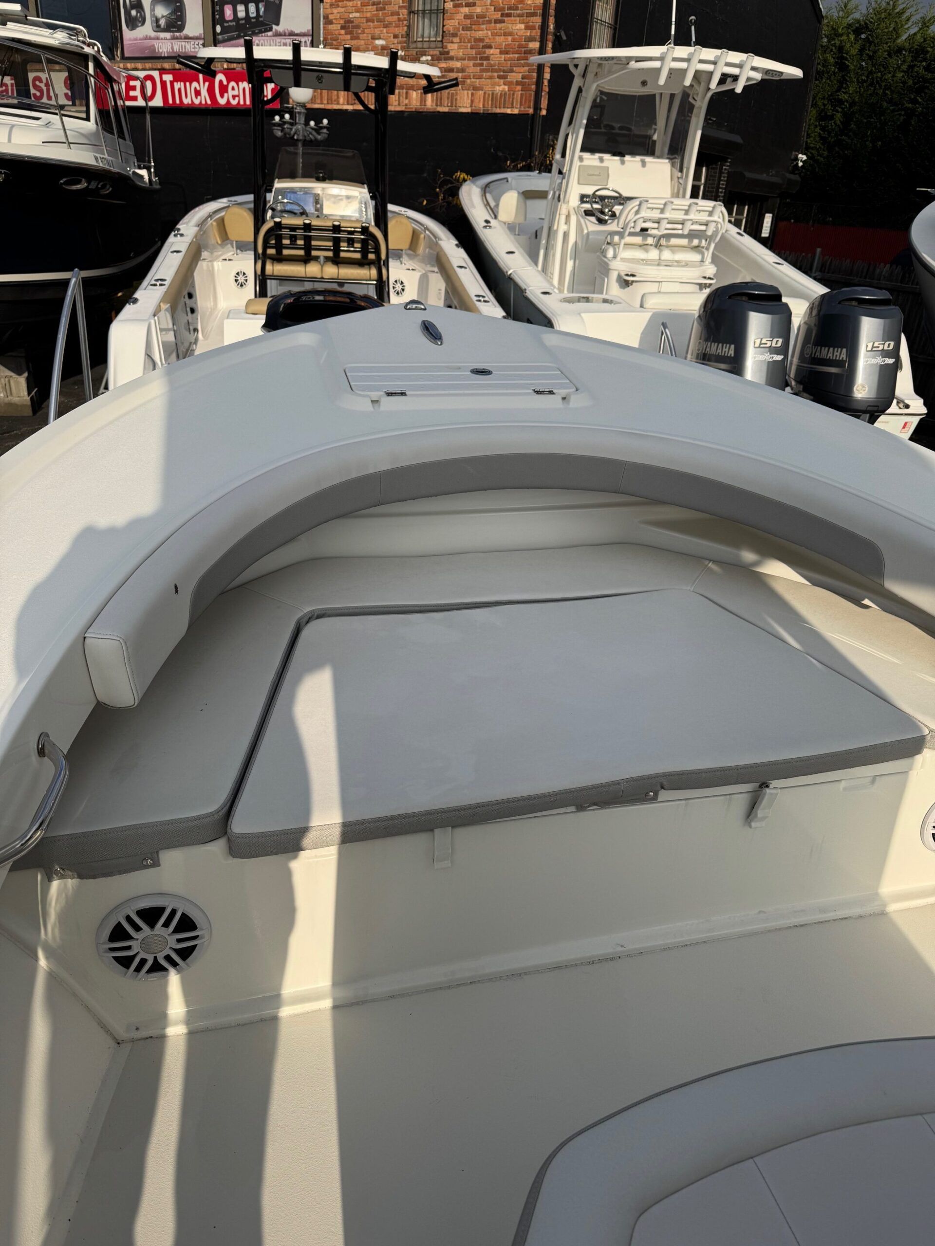 Sportsman Open 232 Center Console 2023: Spacious deck with seating area and speaker, ideal for fishing trips.