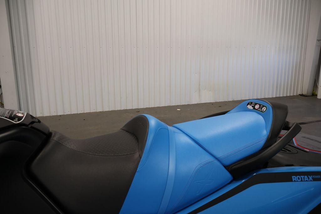 2026 Sea-Doo RXT-X 325 jet ski with blue seat in a garage setting.