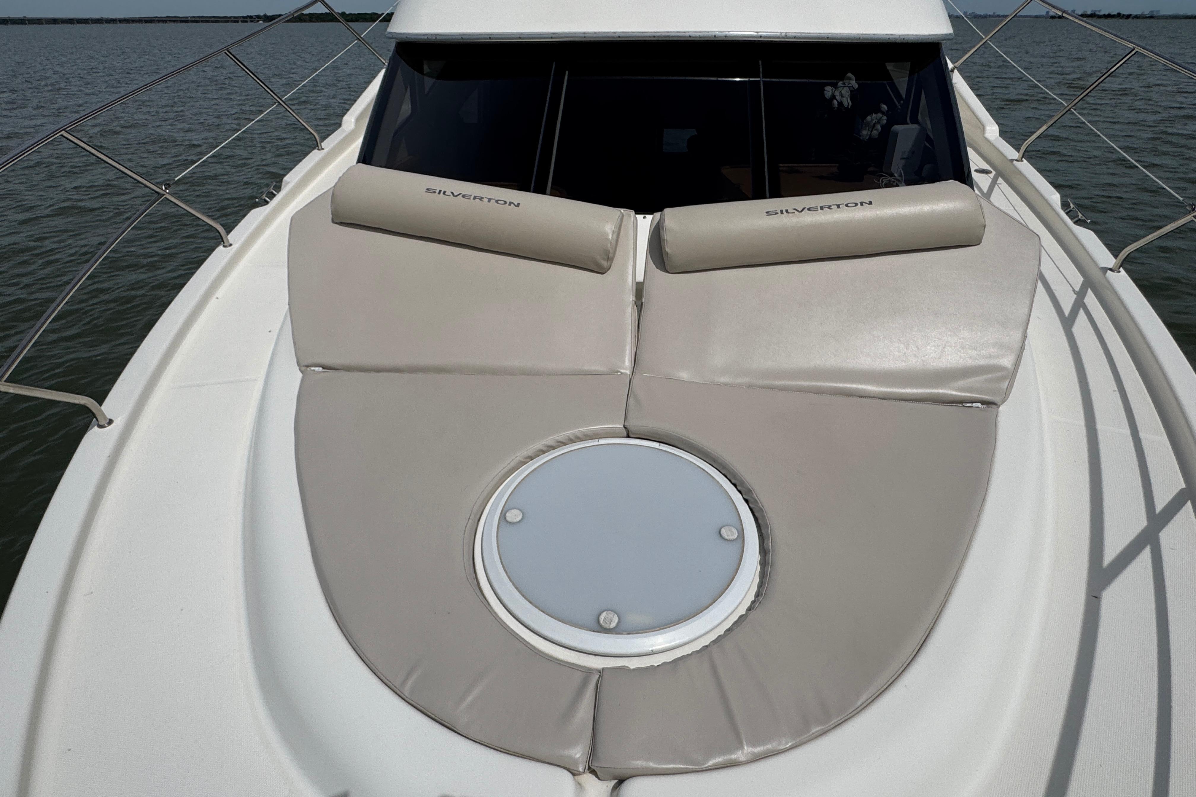 2003 Silverton 39 Motor Yacht deck with cushioned seating and circular hatch.