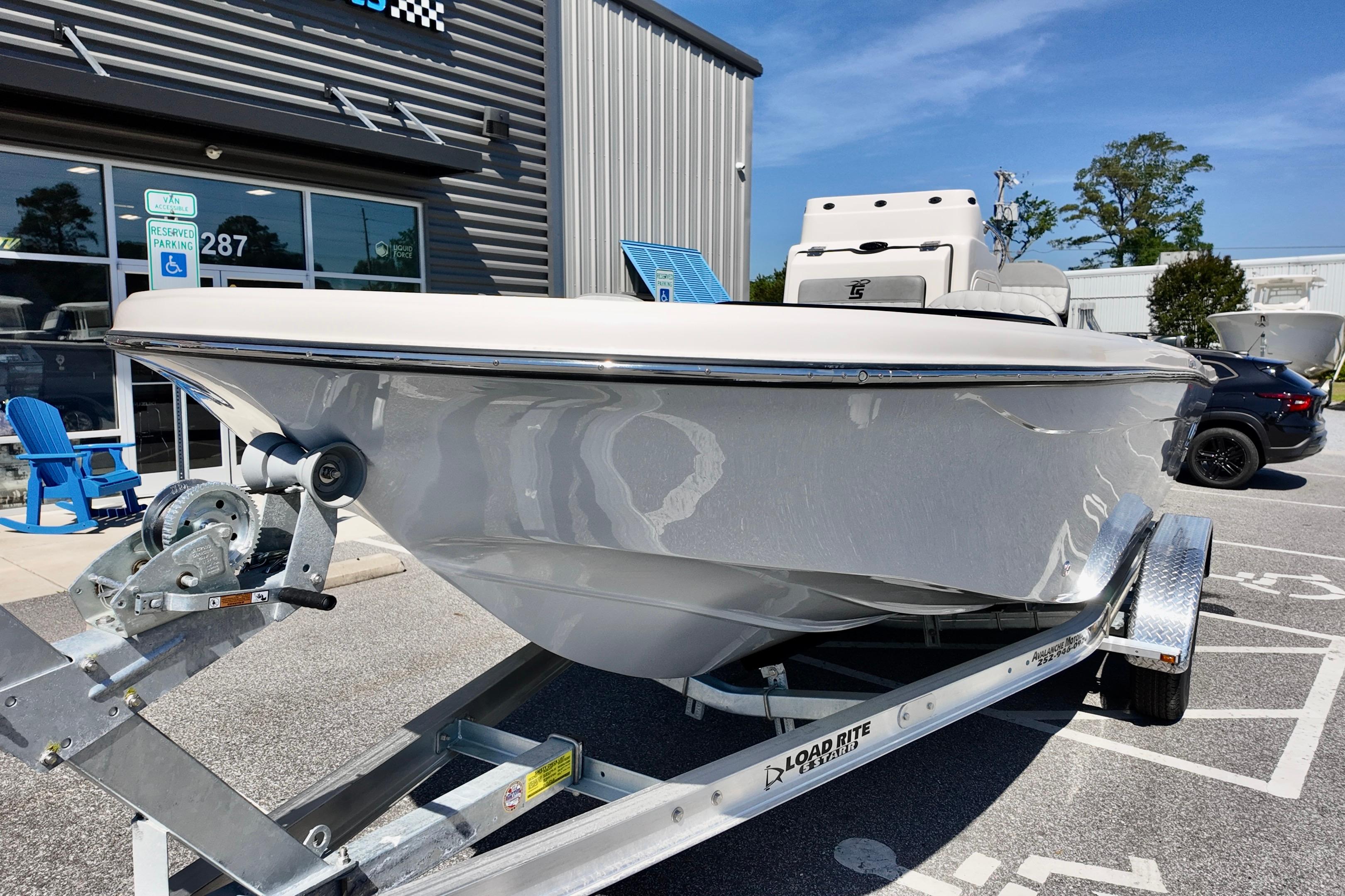 2026 Carolina Skiff 21 Ultra Elite boat on trailer outside dealership.