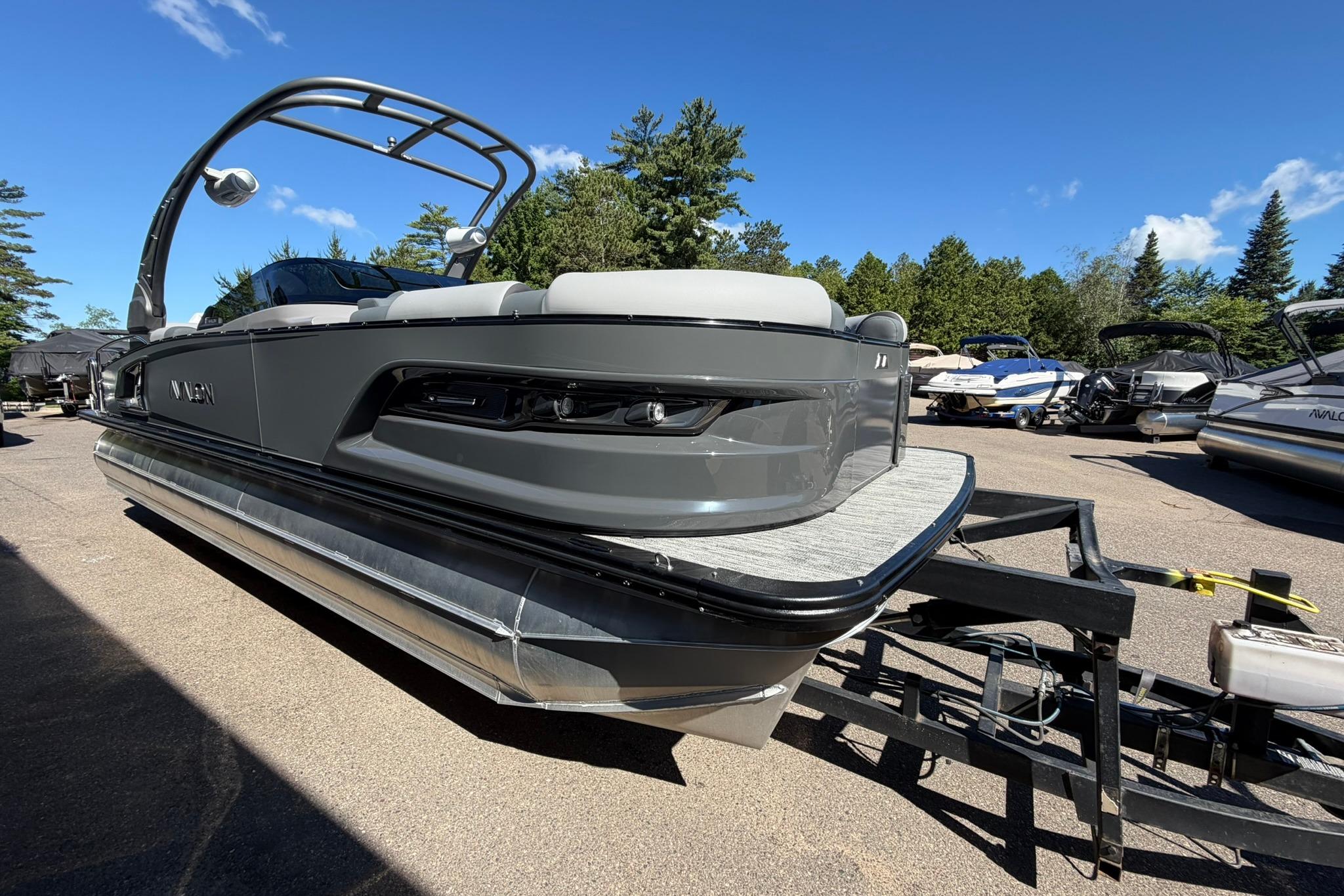 2026 Avalon Excalibur LTD Quad Lounge pontoon boat on trailer, under clear blue sky.