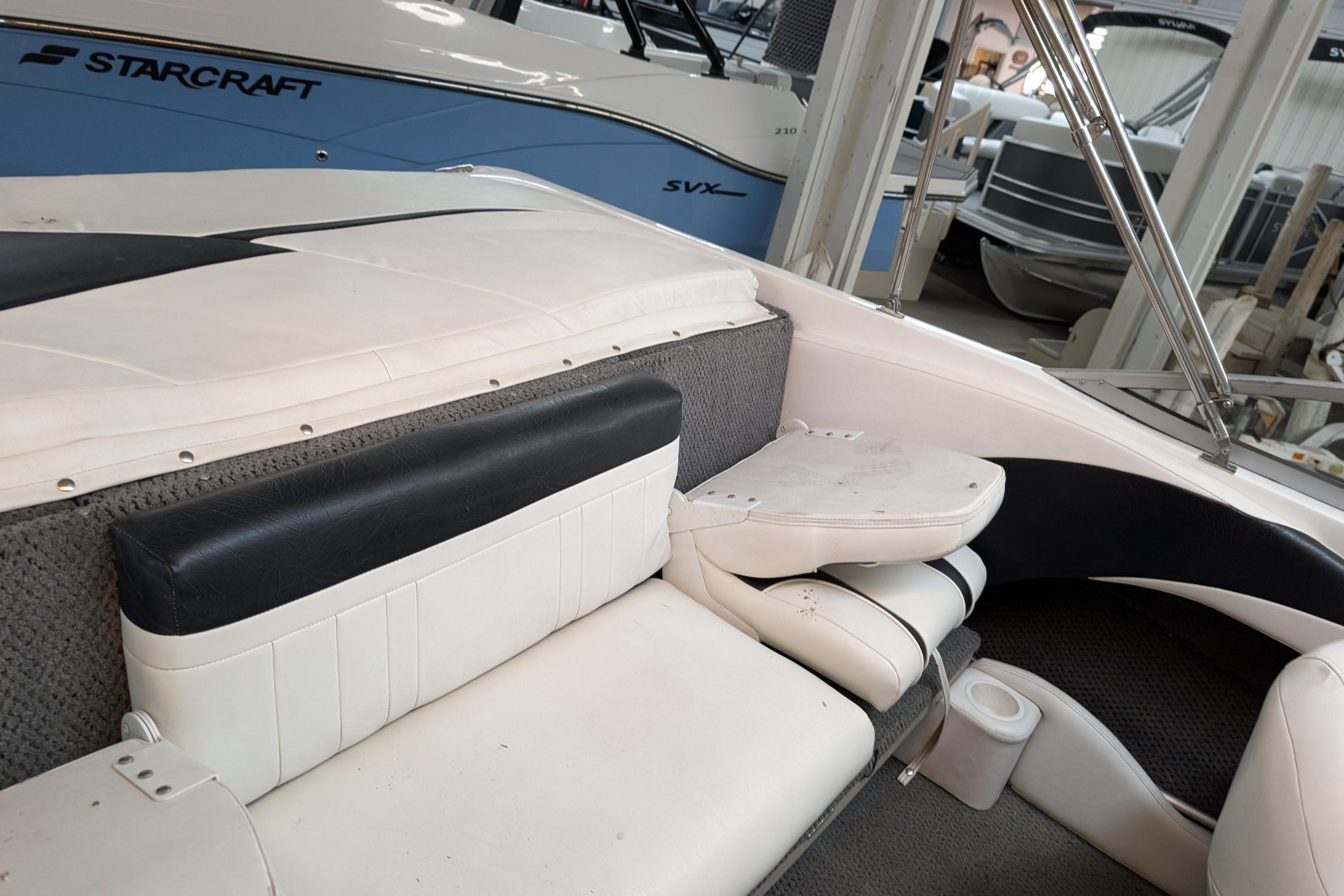 2005 Sylvan V190 I/O boat interior with white and black seating, docked indoors.