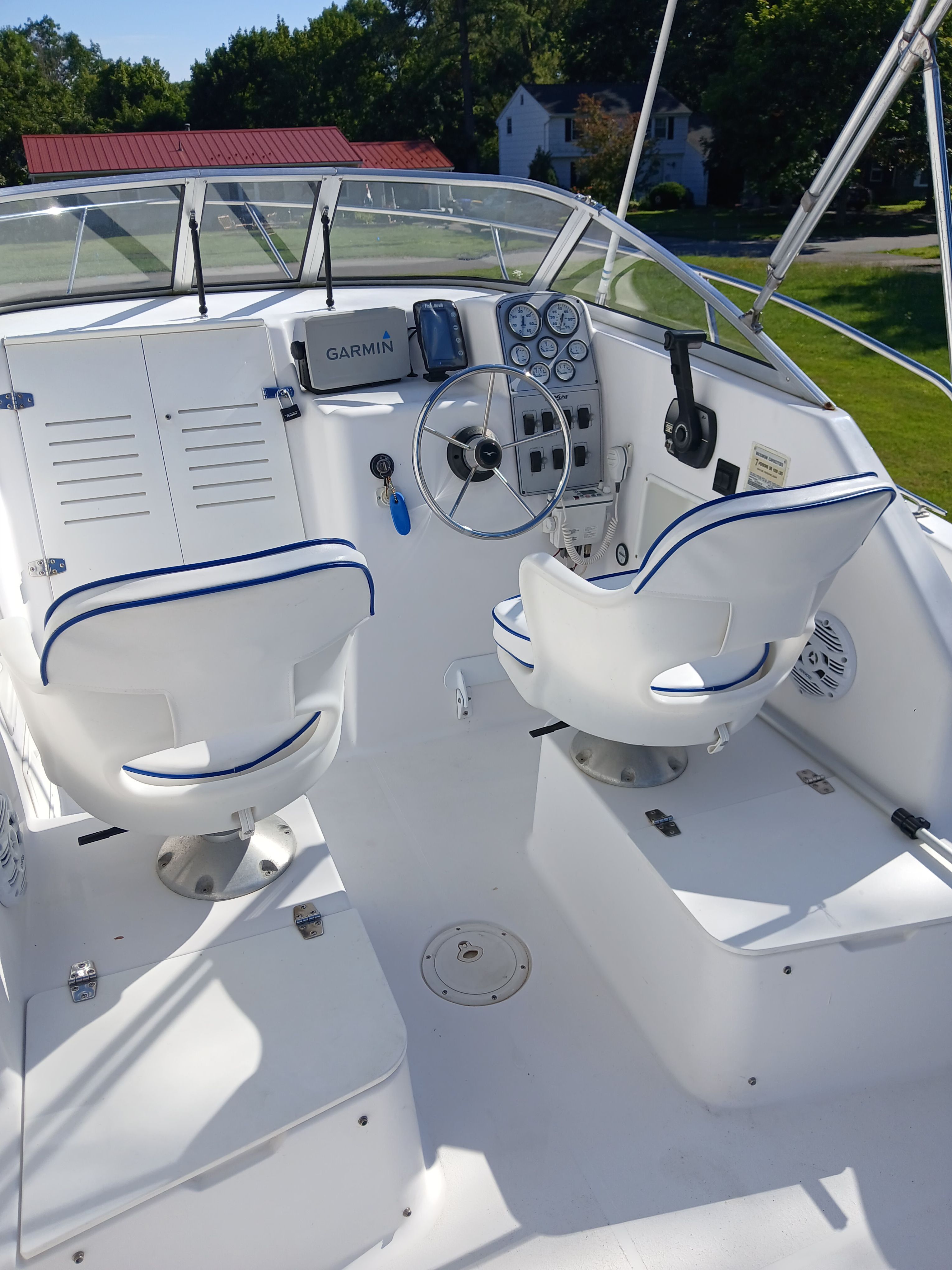 The image shows the cockpit of a 1999 Pro-Line 201 Walkaround boat with two white seats and a helm.