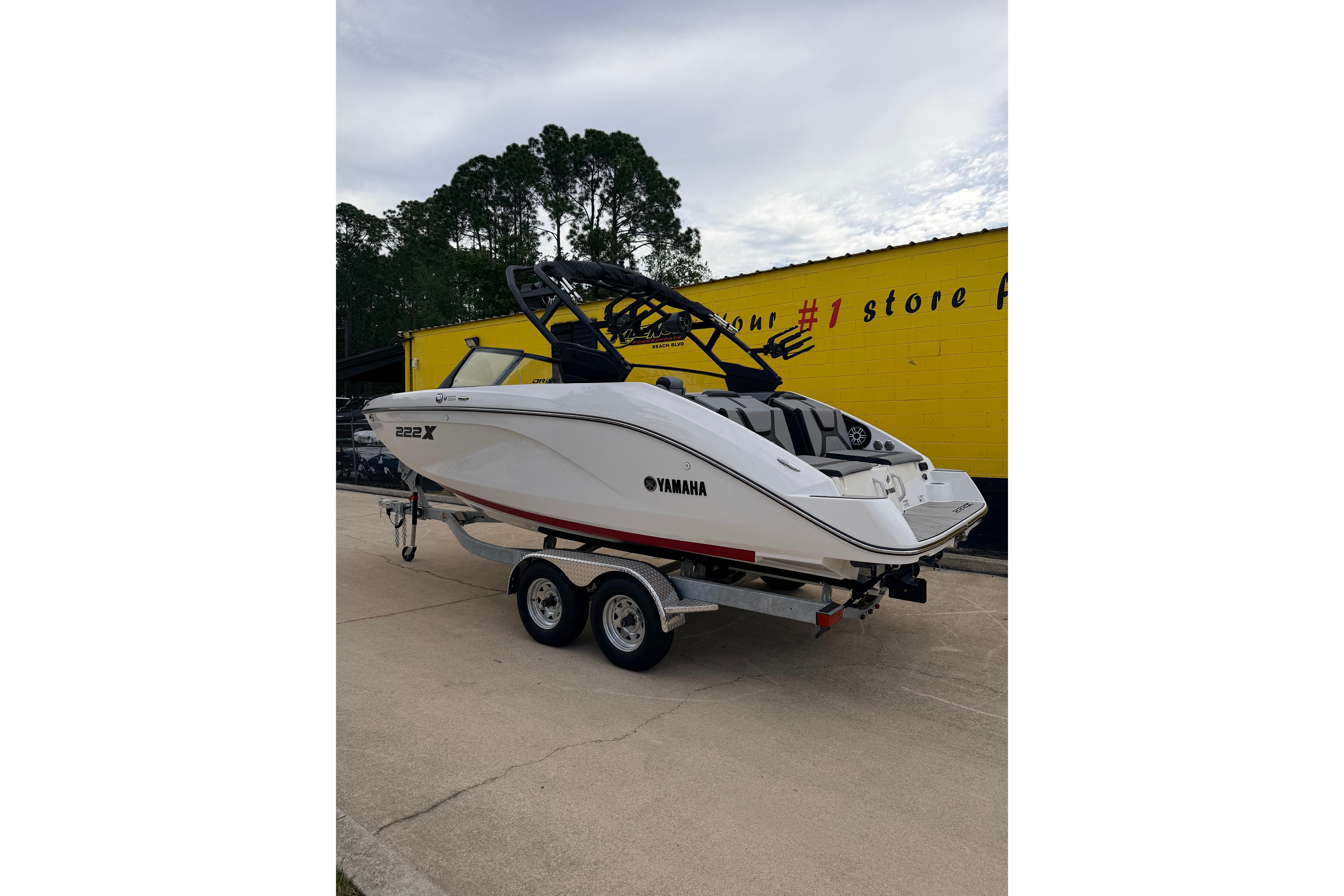 2026 Yamaha Boats 222XD on trailer in front of yellow building.