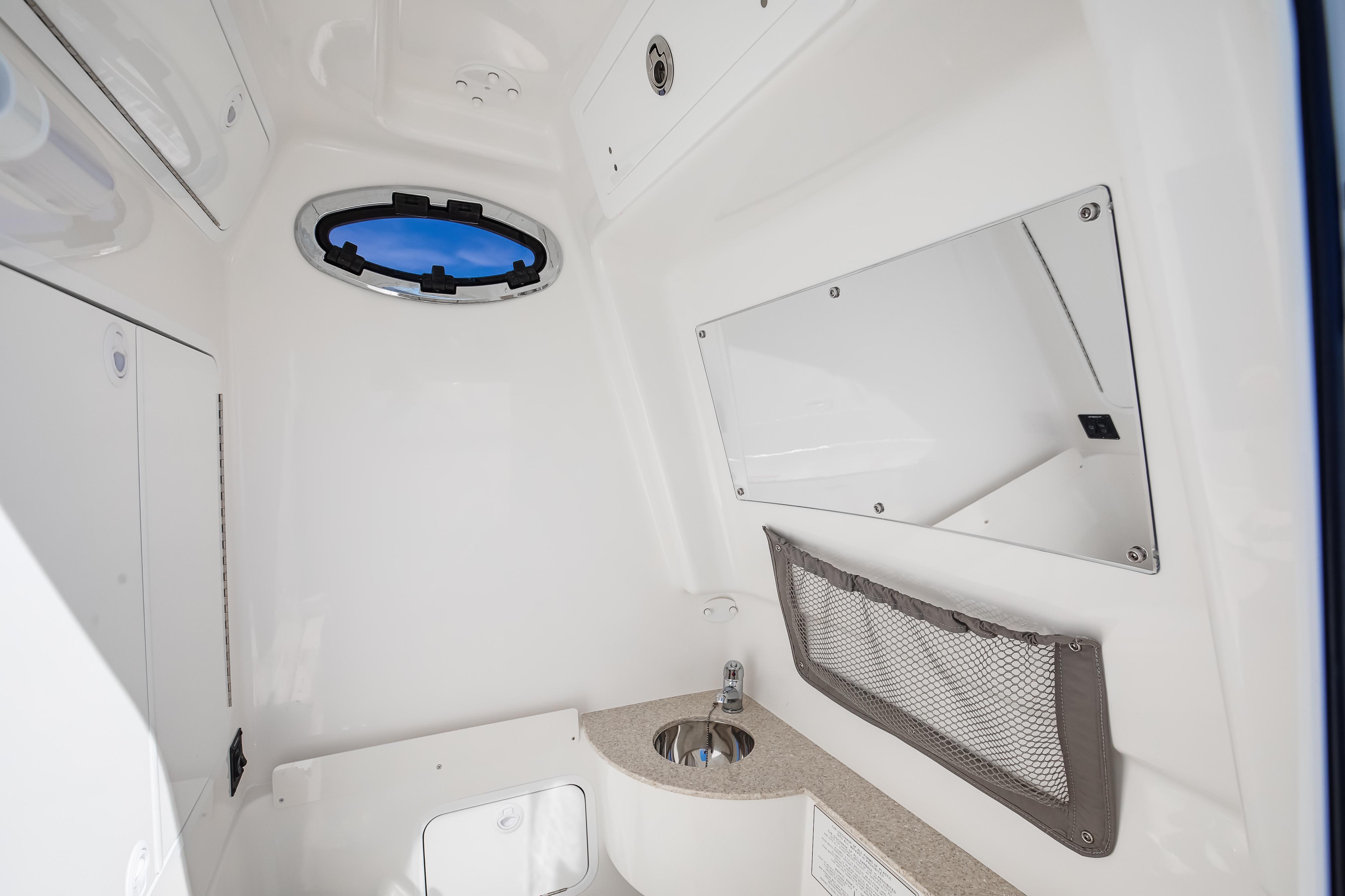 2022 Regulator 28 Forward Seating interior with porthole, sink, and storage net.