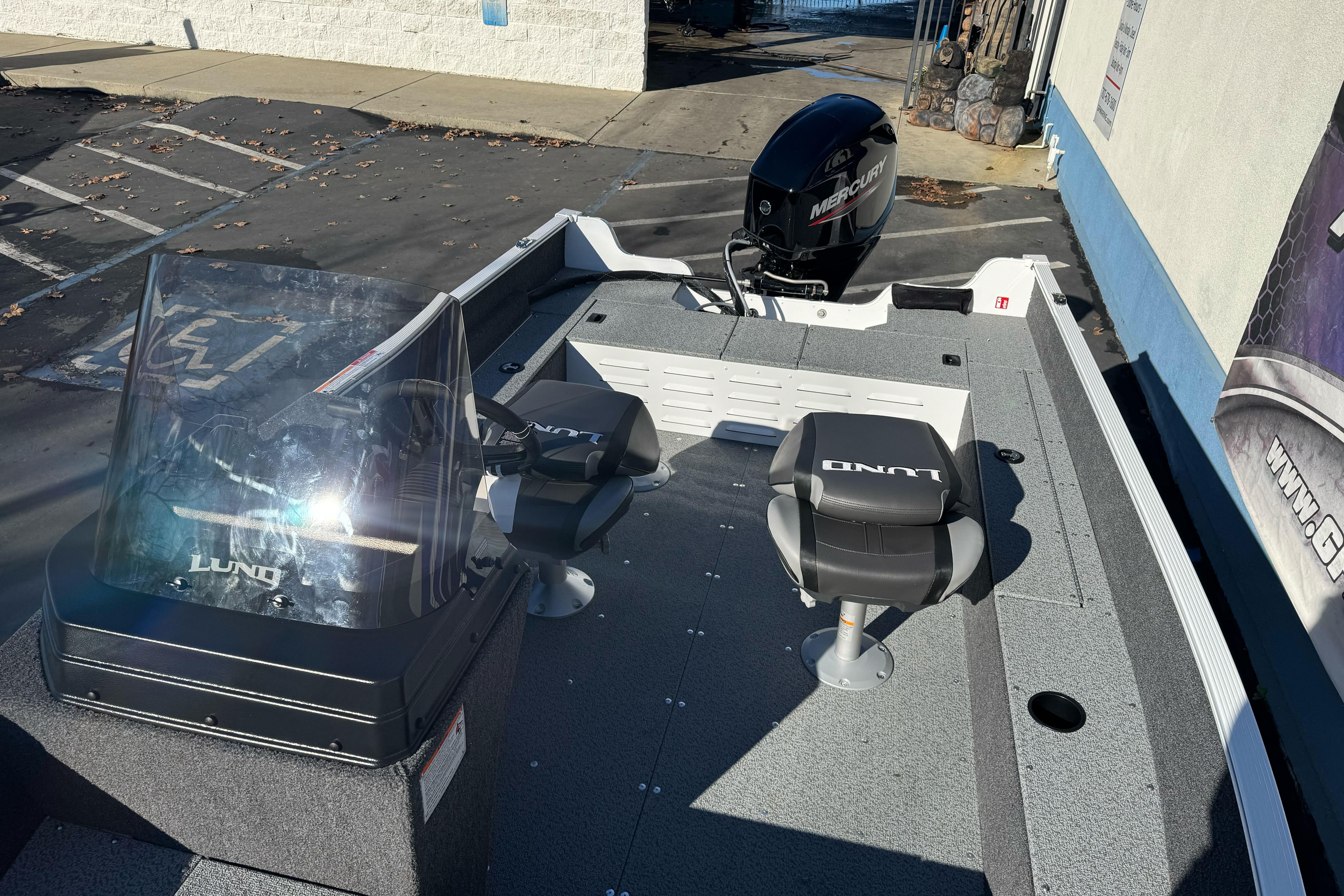 2026 Lund 1650 Angler SS boat with Mercury engine, featuring dual seats and windshield.