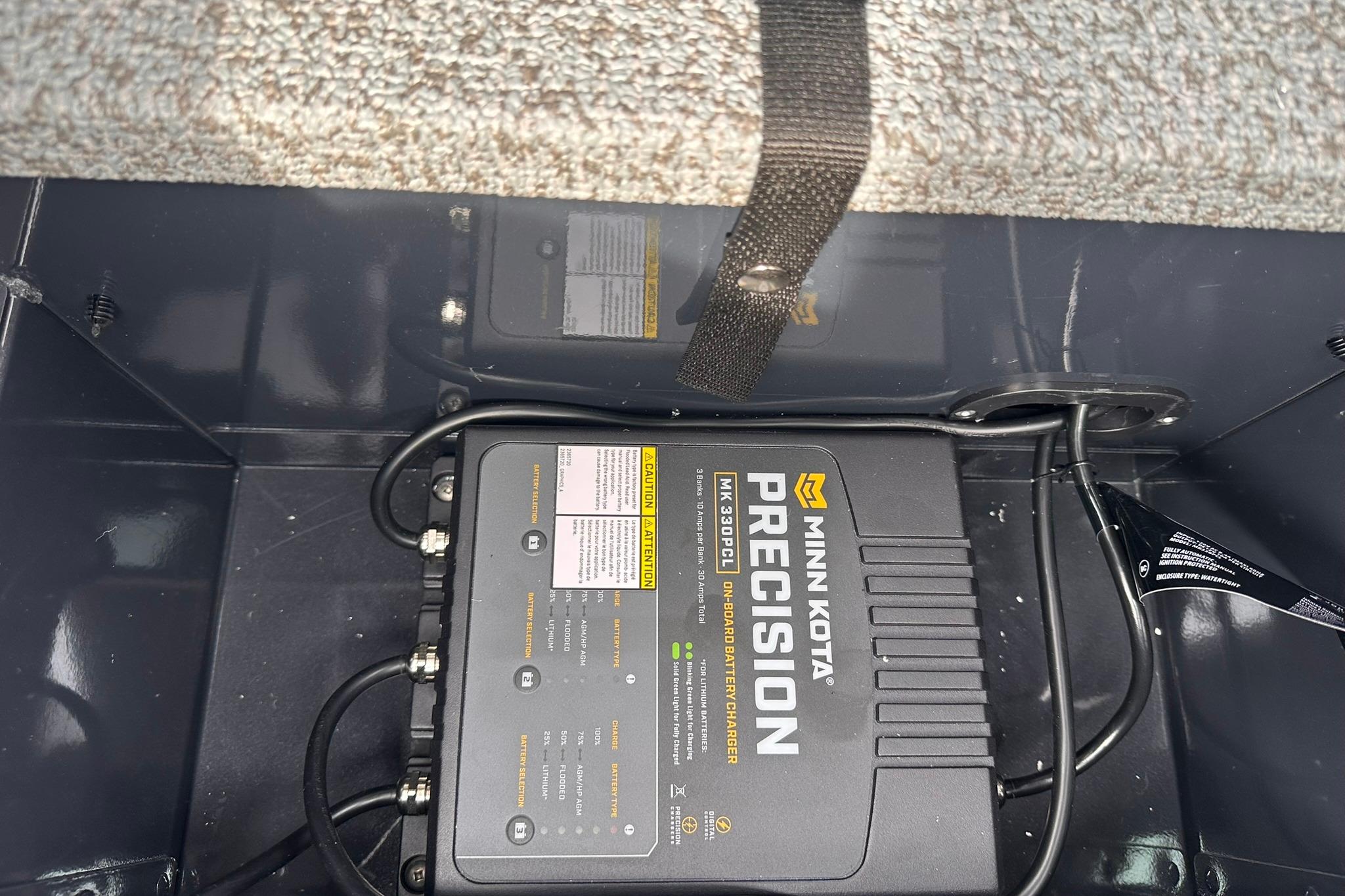 Minn Kota Precision battery charger in 2026 Lund 1775 Adventure Sport boat compartment.