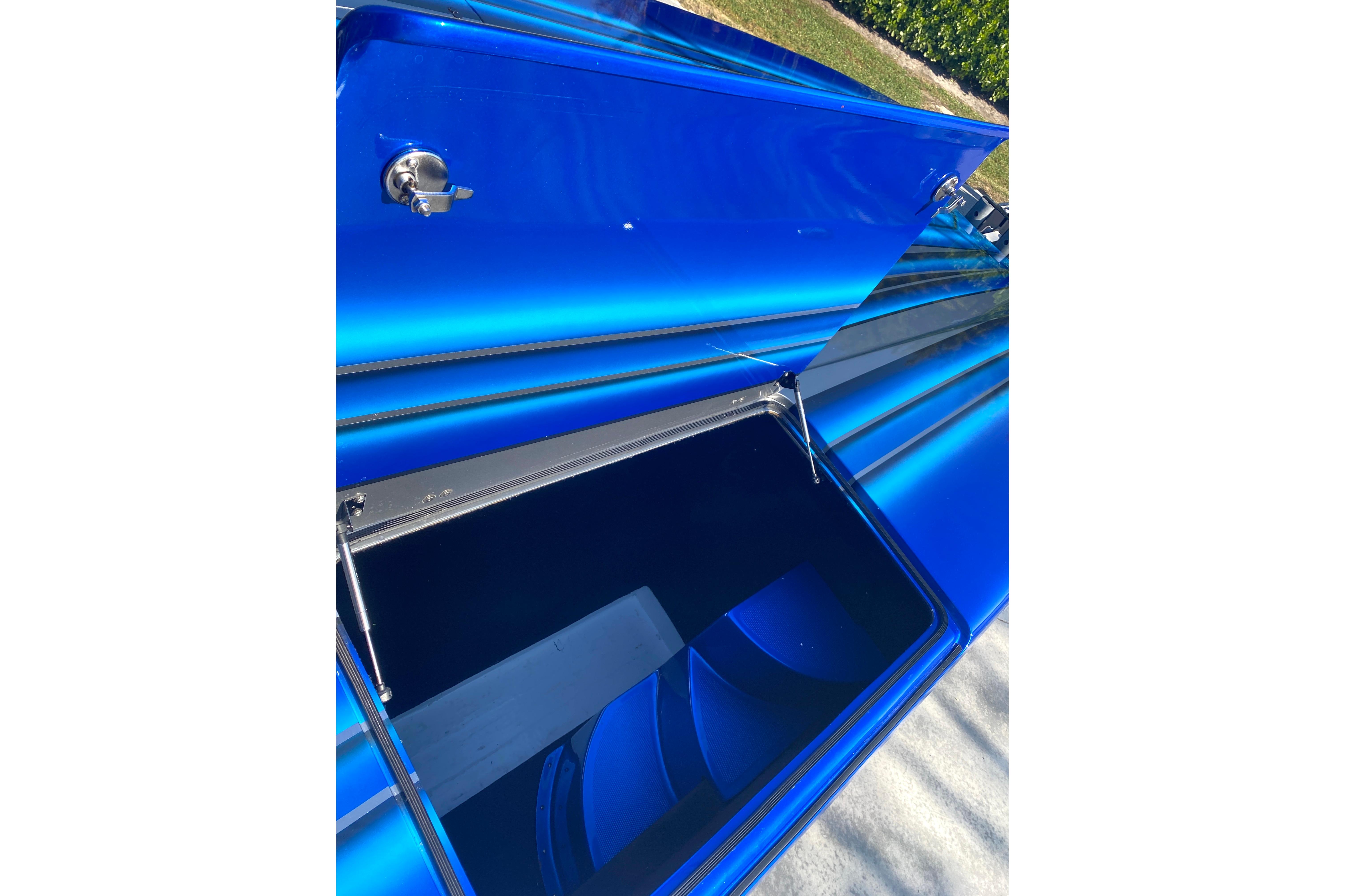 Open storage compartment on a 2016 MTI 44 RP boat, featuring a vibrant blue finish.